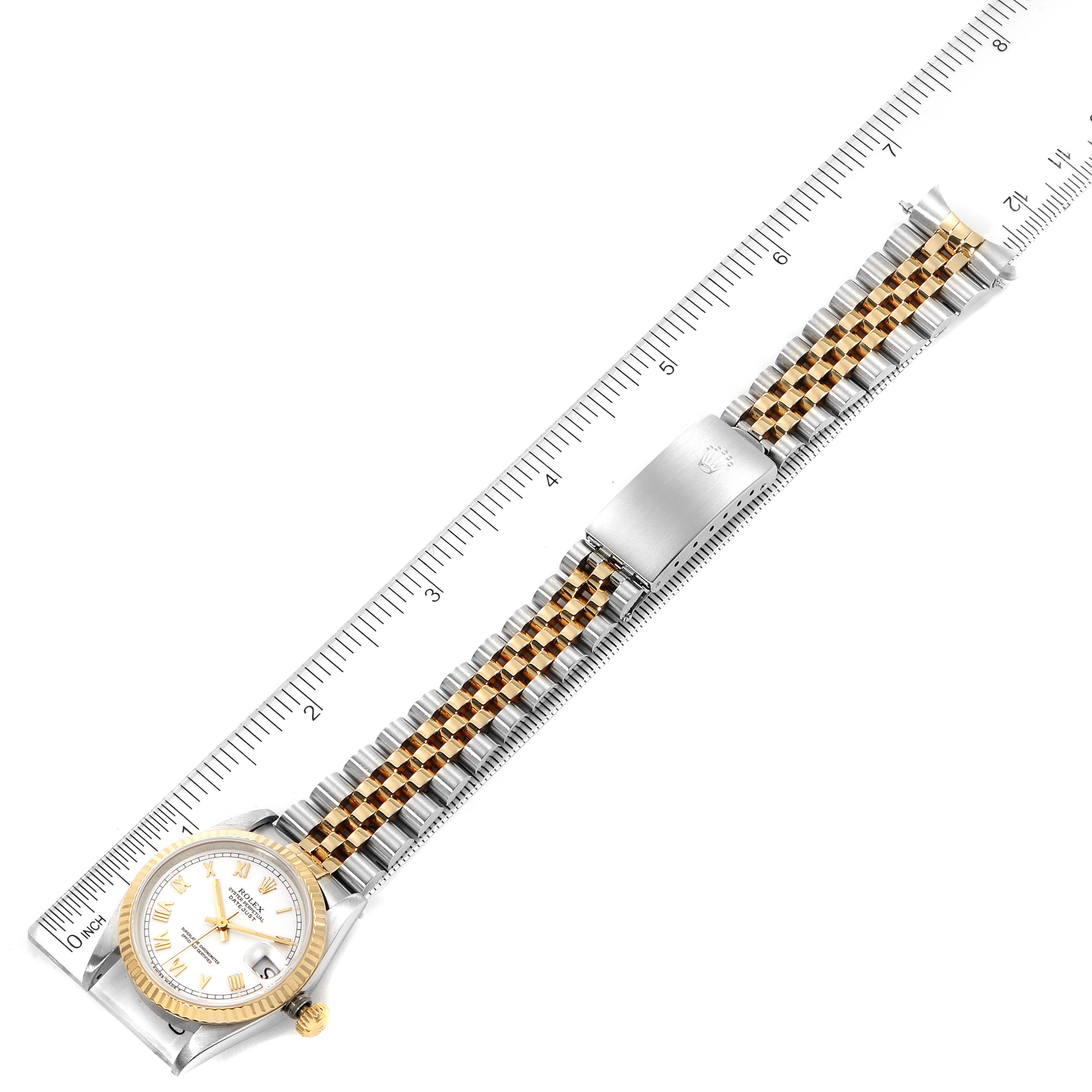 The image shows a Rolex Mid-Size 68273 Women
s Steel and Gold (two tone) White Dial 68273 Women
s Steel and Gold (two tone) White Dial watch laid flat next to a ruler, displaying the face, bezel, and bracelet.