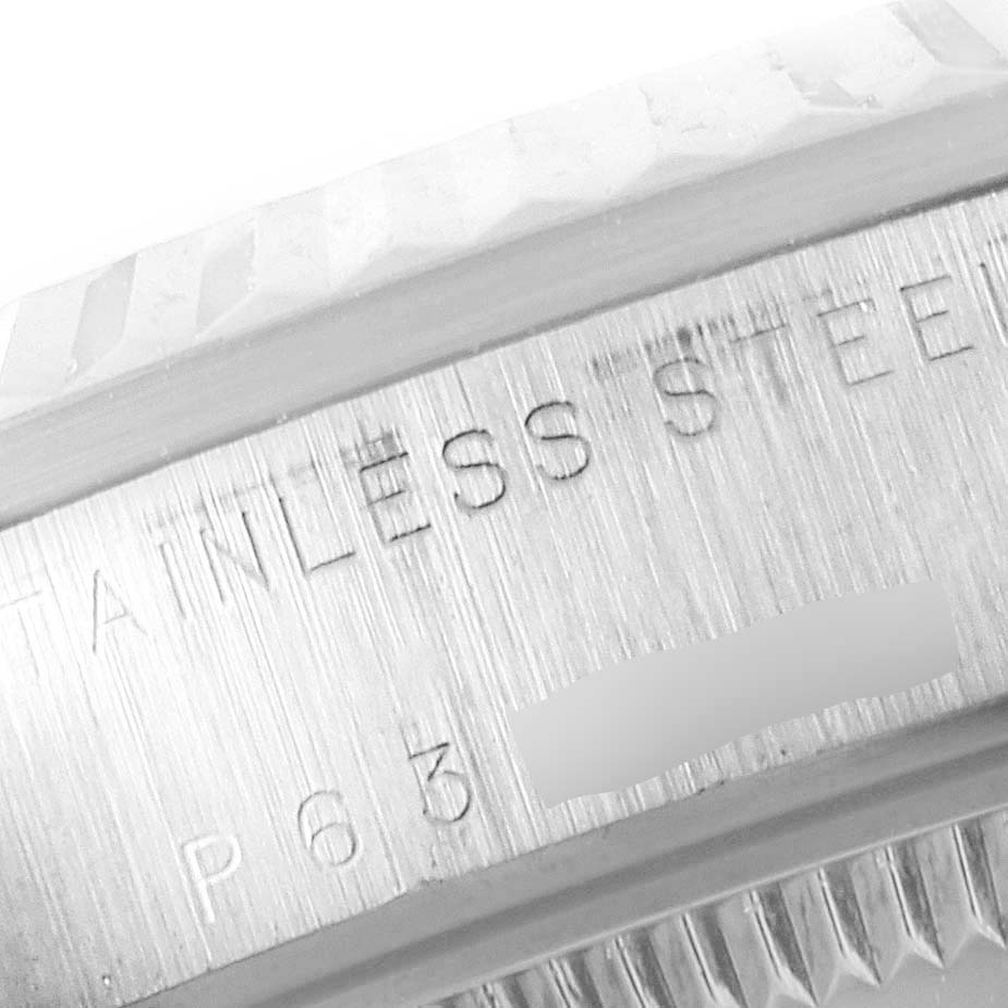 The image shows a close-up of the case and bezel of a Mid-Size Rolex watch, highlighting the "Stainless Steel" engraving.