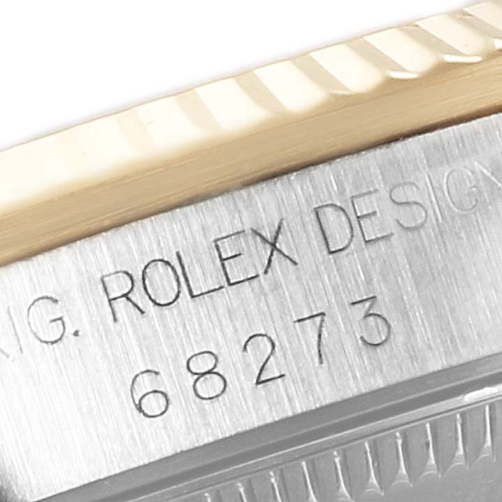This close-up image shows part of the bezel and case side of a Mid-Size Rolex watch, with the model number visible.