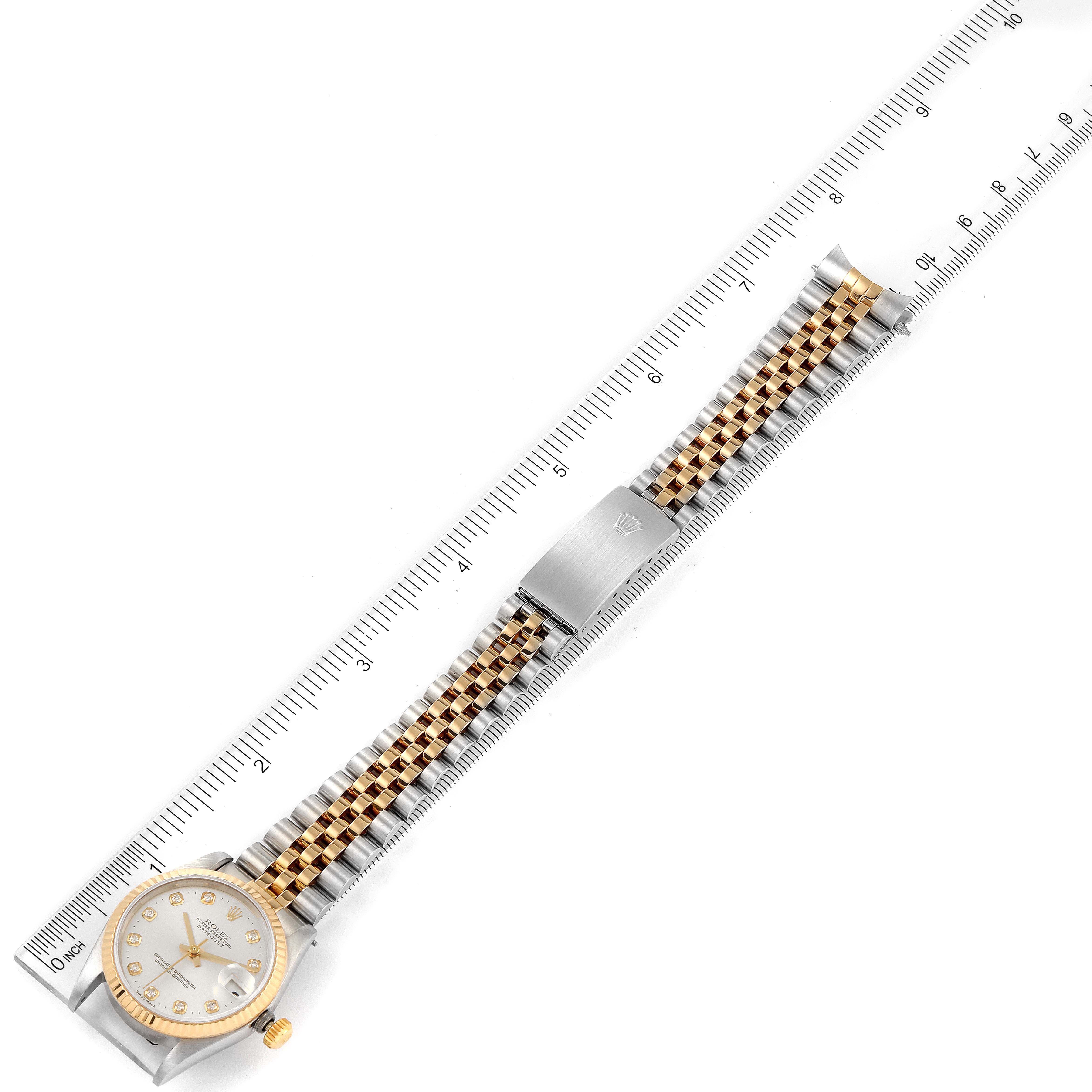 The image shows a Rolex Mid-Size 68273 Women
s Steel and Gold (two tone) Silver Dial 68273 Women
s Steel and Gold (two tone) Silver Dial watch laid out flat, including the face, bezel, crown, and two-tone bracelet, measured against a ruler.