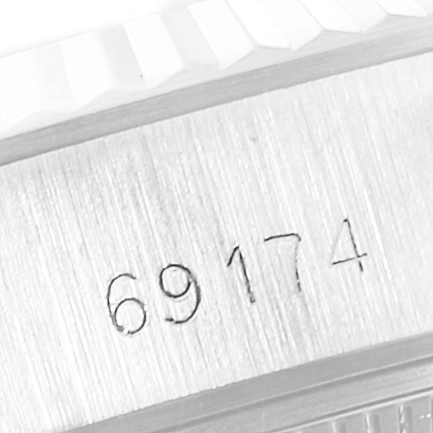 The image shows a close-up of the engraved serial number on the side of a Rolex Datejust 69174 Women
s Stainless Steel Silver Dial 69174 Women
s Stainless Steel Silver Dial watch case.