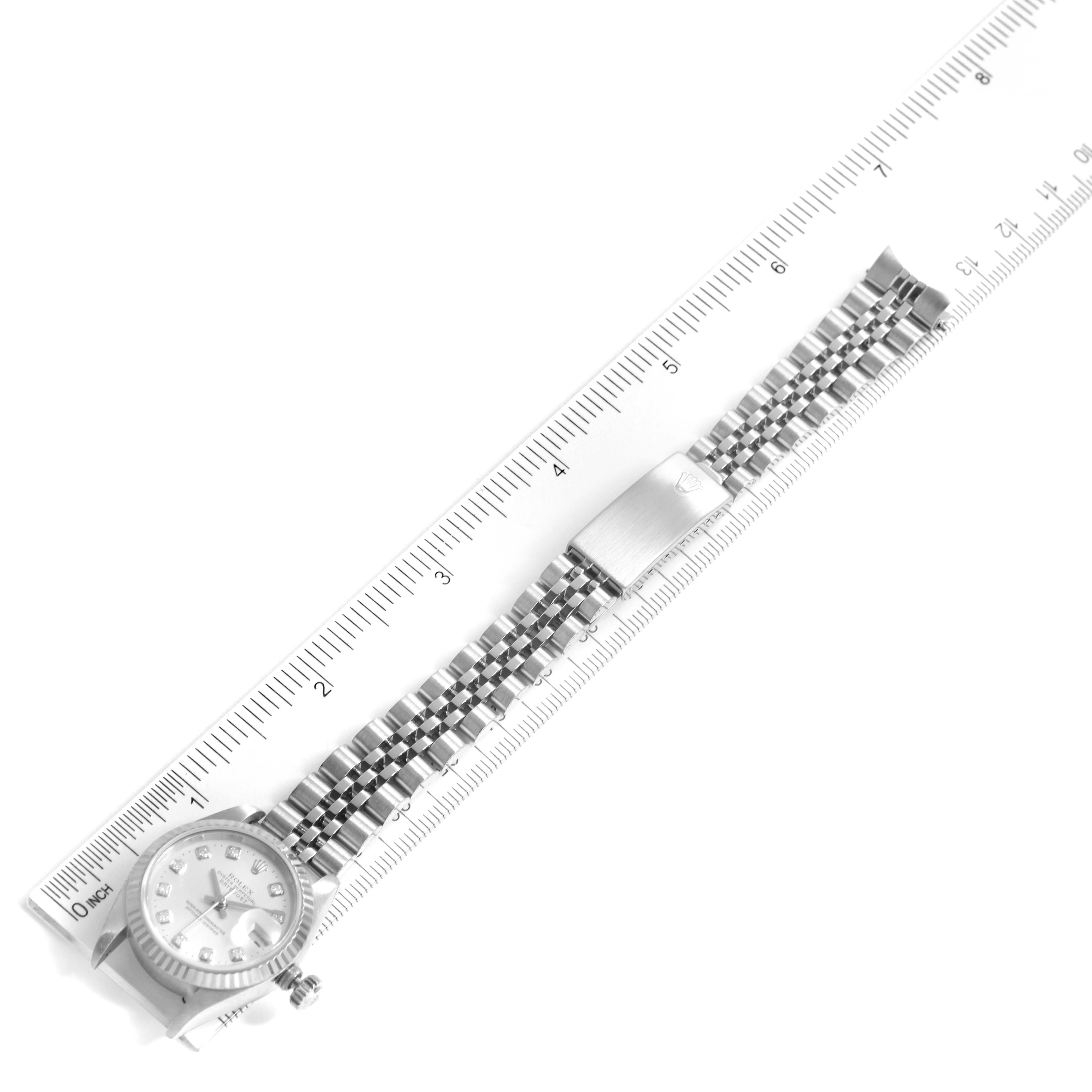 The image shows a top view of a Rolex Datejust 69174 Women
s Stainless Steel Silver Dial 69174 Women
s Stainless Steel Silver Dial watch and bracelet measured against a ruler.