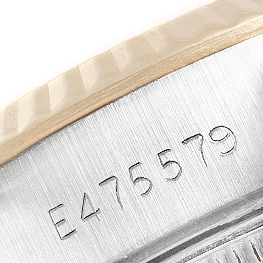 The image shows a close-up angle of the serial number engraved on the side of a Rolex Datejust 69173 Women
s Steel and Gold (two tone) Black Dial 69173 Women
s Steel and Gold (two tone) Black Dial watch bezel.