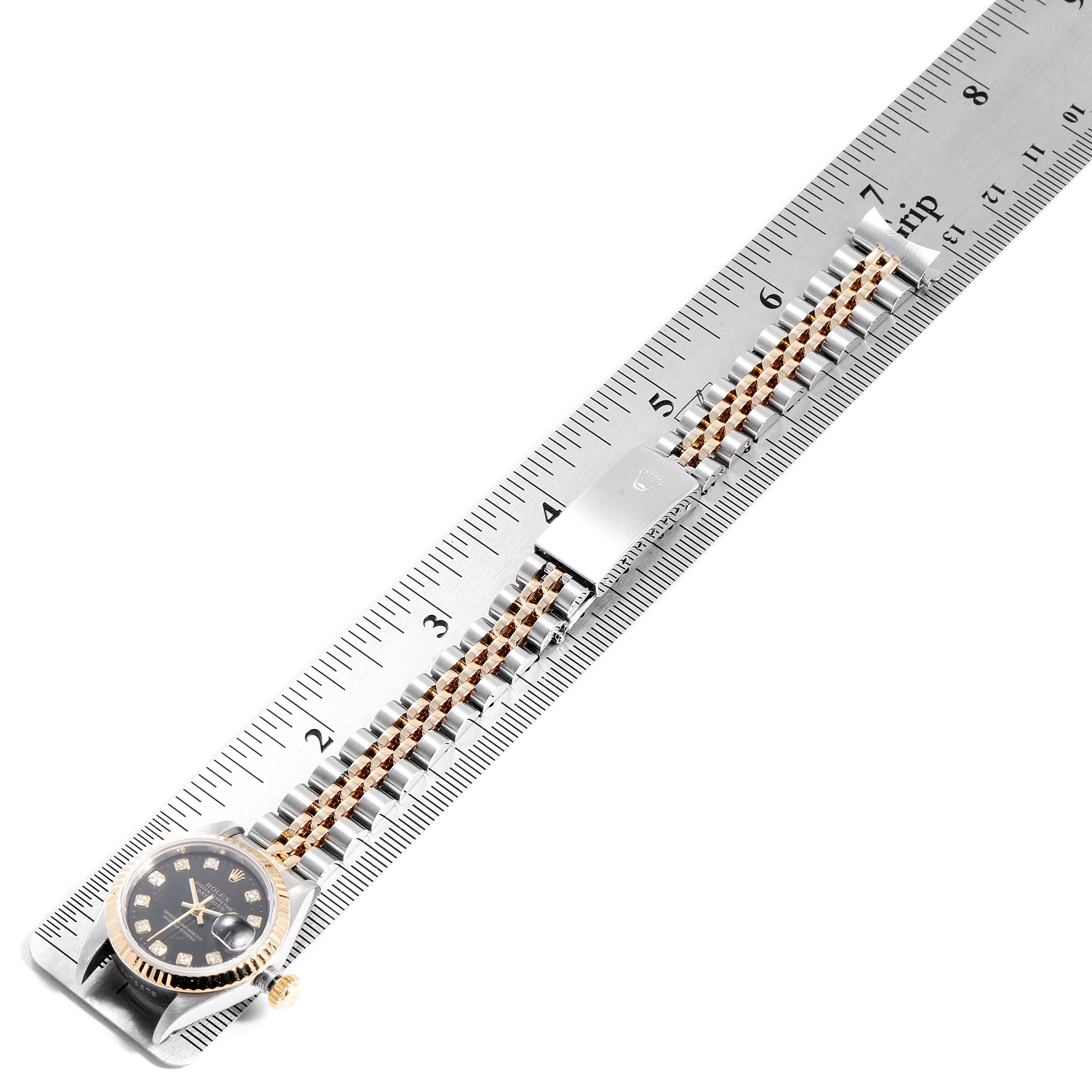 The image shows a Rolex Datejust 69173 Women
s Steel and Gold (two tone) Black Dial 69173 Women
s Steel and Gold (two tone) Black Dial watch placed on a ruler, displaying the face and bracelet from a top-down angle.