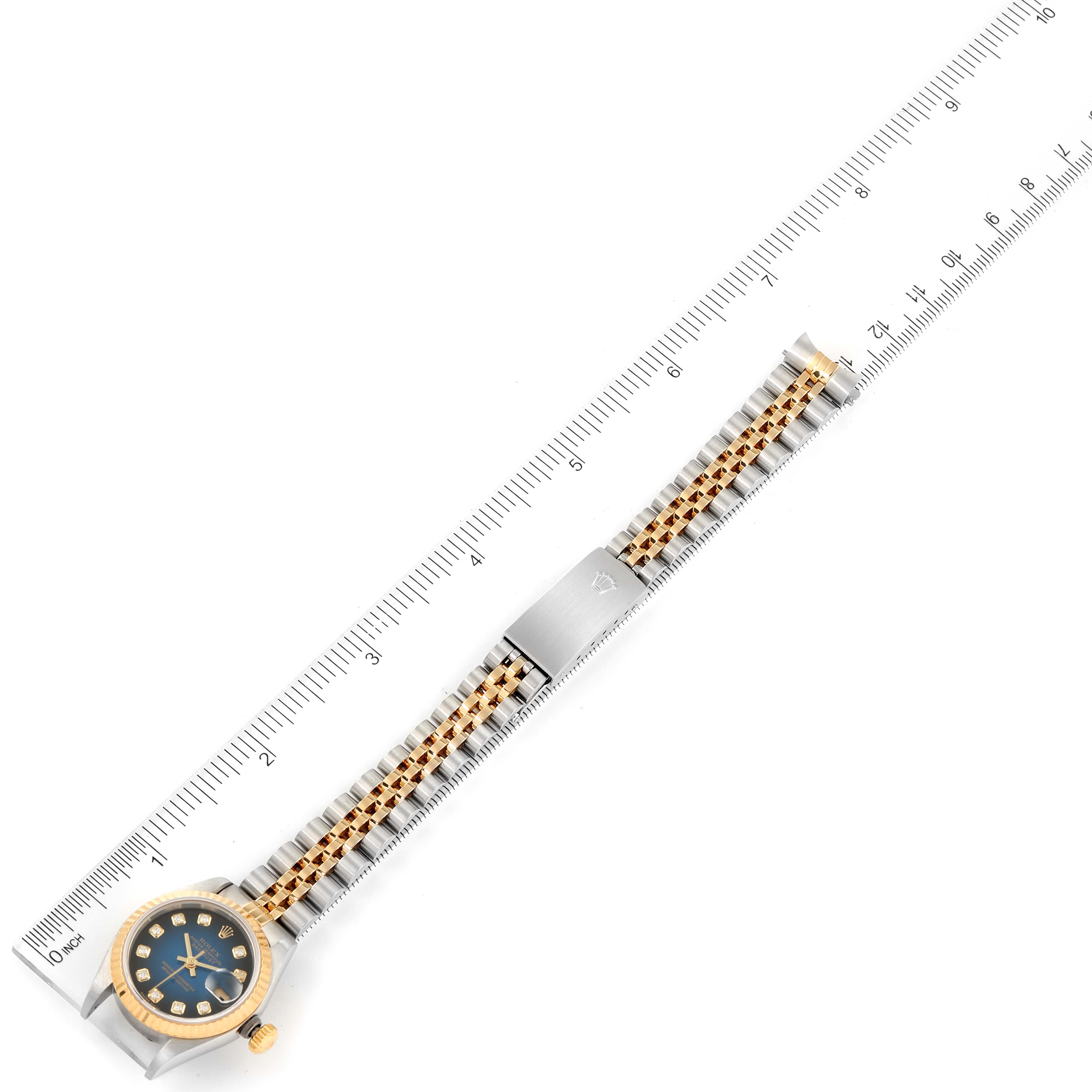 The image shows a Rolex Datejust 79173 Women's Steel and Gold (two tone) Blue Dial 79173 Women's Steel and Gold (two tone) Blue Dial watch laid flat alongside a ruler, displaying its entire bracelet and dial.