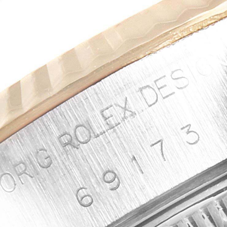 The image shows a close-up of the engraved bezel and case of a Rolex Datejust 69173 Women
s Steel and Gold (two tone) Champagne Dial 69173 Women
s Steel and Gold (two tone) Champagne Dial model.