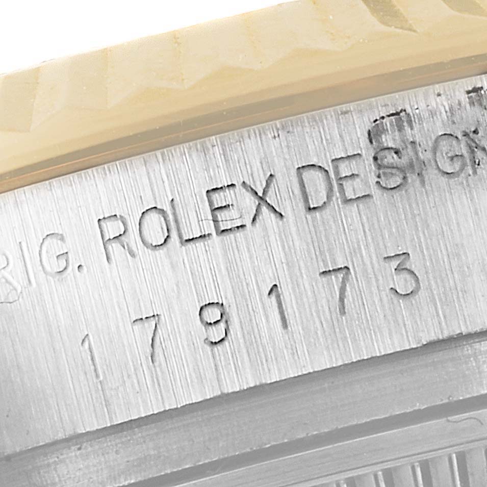 This close-up image shows the engraved serial number and part of the fluted bezel of a Rolex Datejust 179173 Women's Steel and Gold (two tone) Mother of Pearl Dial 179173 Women's Steel and Gold (two tone) Mother of Pearl Dial watch.