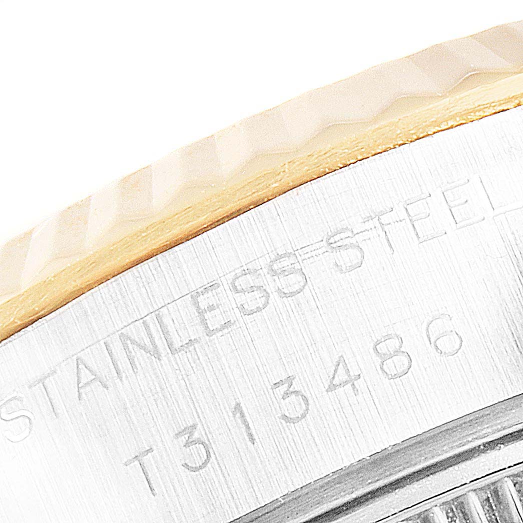This close-up image shows the stainless steel and gold bezel of a Rolex Datejust 69173 Women
s Steel and Gold (two tone) White Dial 69173 Women
s Steel and Gold (two tone) White Dial watch, with part of the serial number engraved.