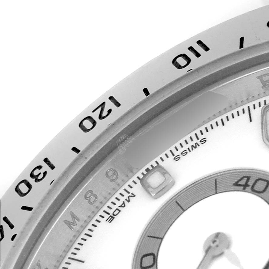 The image shows a close-up of the bezel and part of the dial of a Rolex Daytona 116520 Men's Stainless Steel White Dial watch.