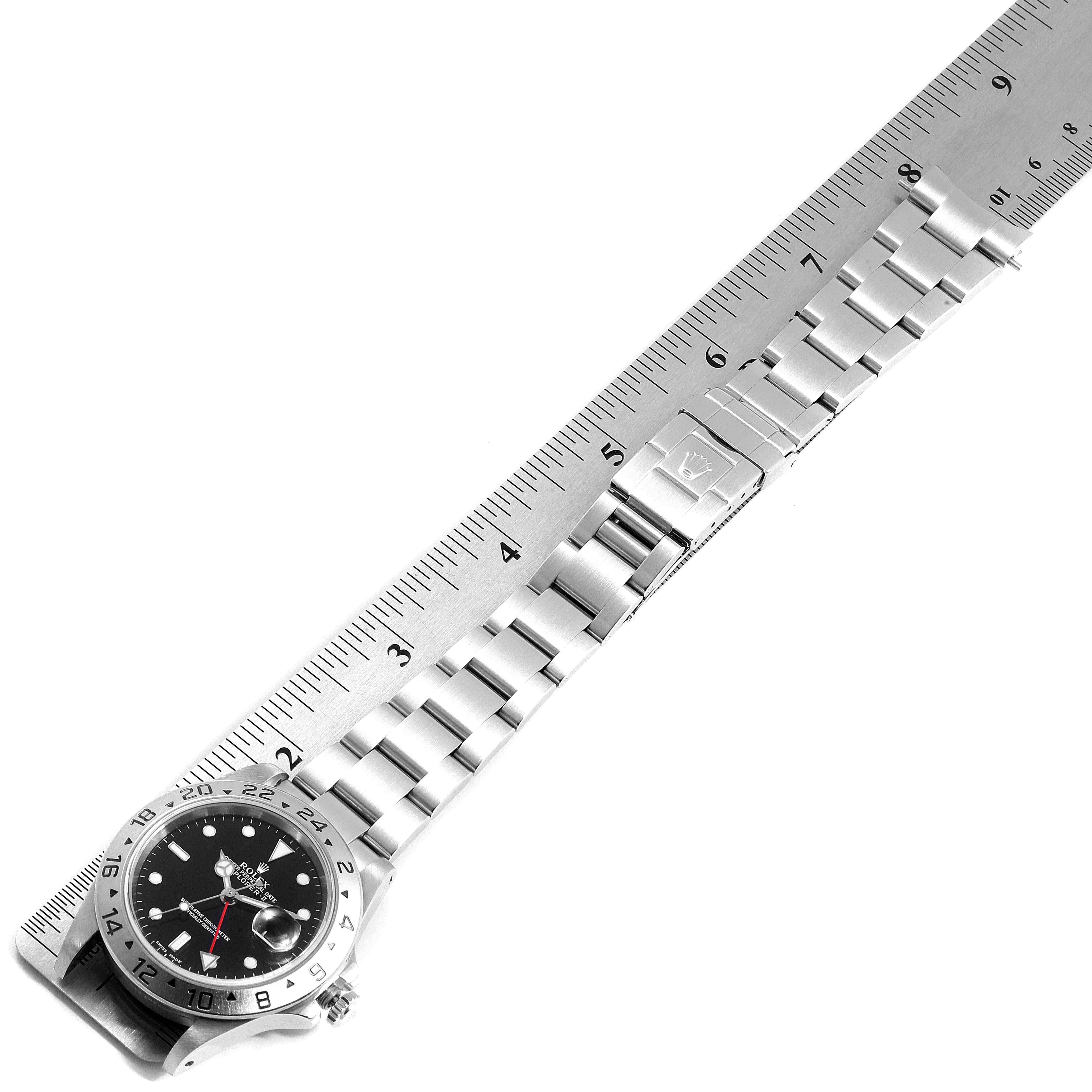 The image shows a Rolex Explorer 16570 Men
s Stainless Steel Black Dial 16570 Men
s Stainless Steel Black Dial model watch laid flat, highlighting its bracelet and clasp against a ruler for scale.