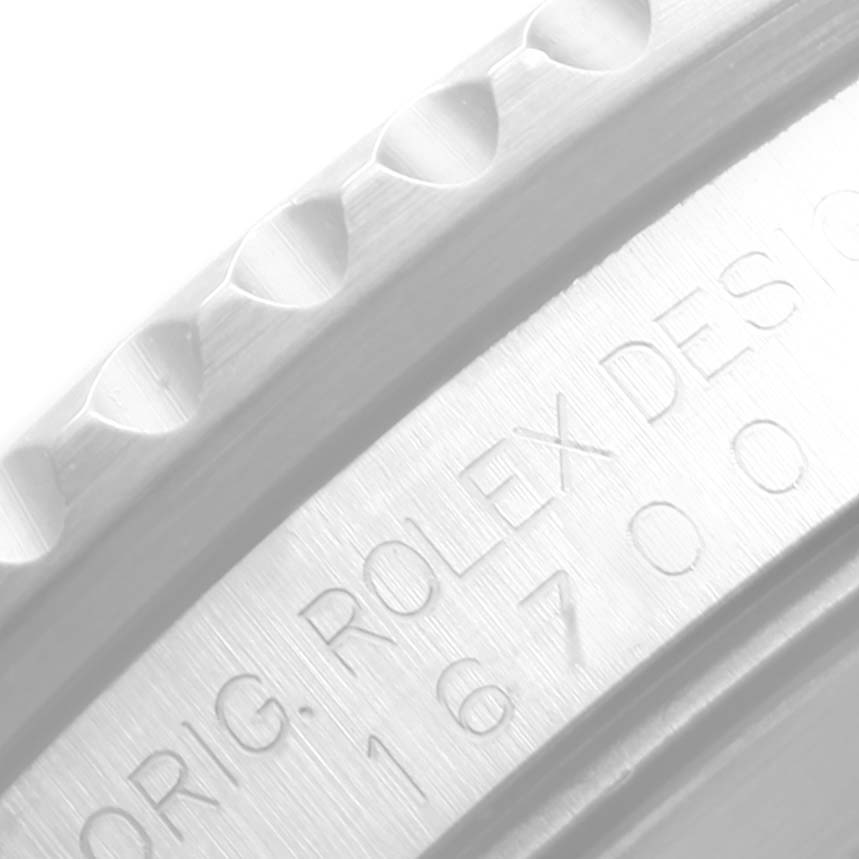 This close-up image of a Rolex GMT-Master 16700 Men
s Stainless Steel Black Dial 16700 Men
s Stainless Steel Black Dial watch model shows part of the bezel and engraved text on the case.