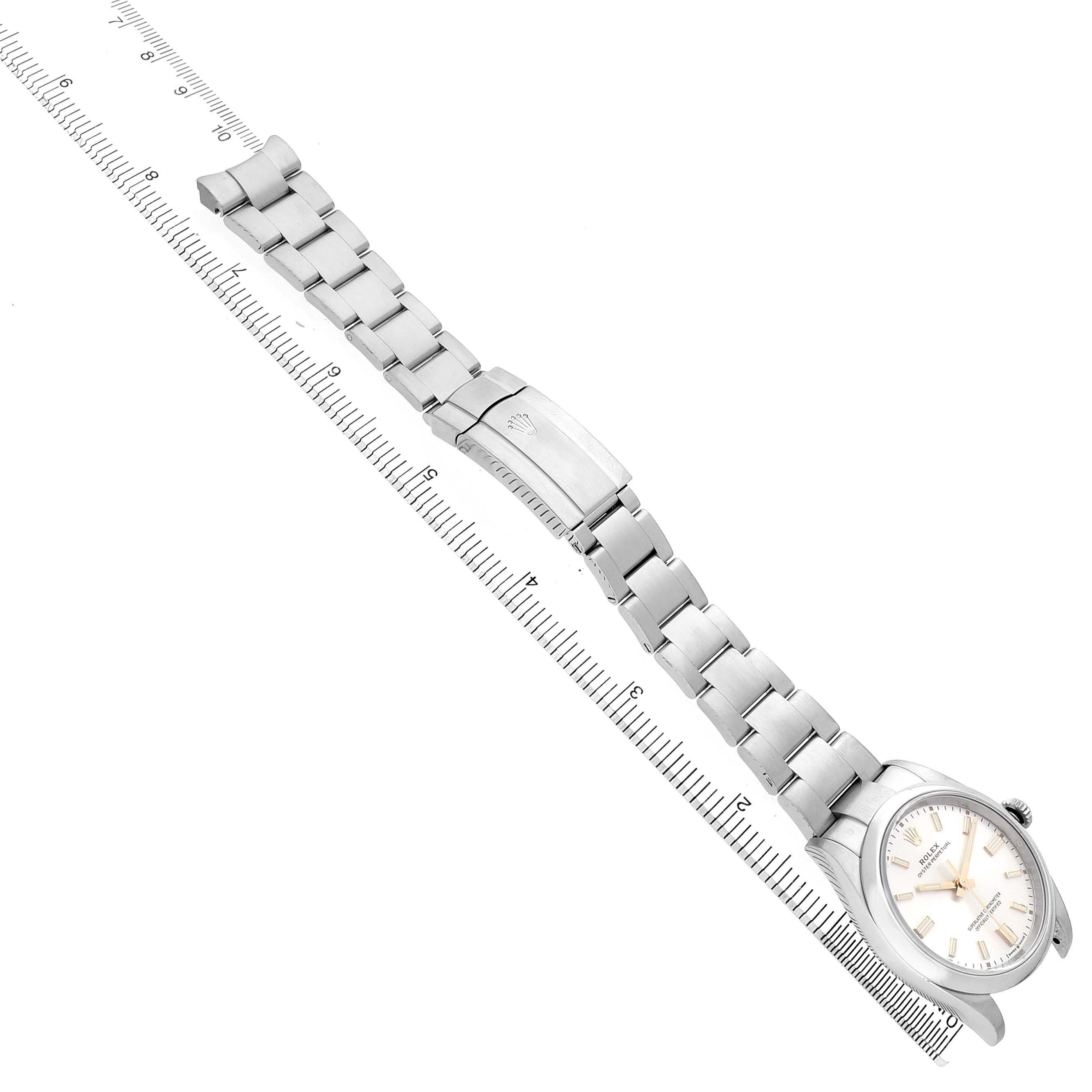 The Rolex Oyster Perpetual 126000 Men's Stainless Steel Silver Dial watch is shown at an angle displaying the full bracelet and face, with a ruler for scale.