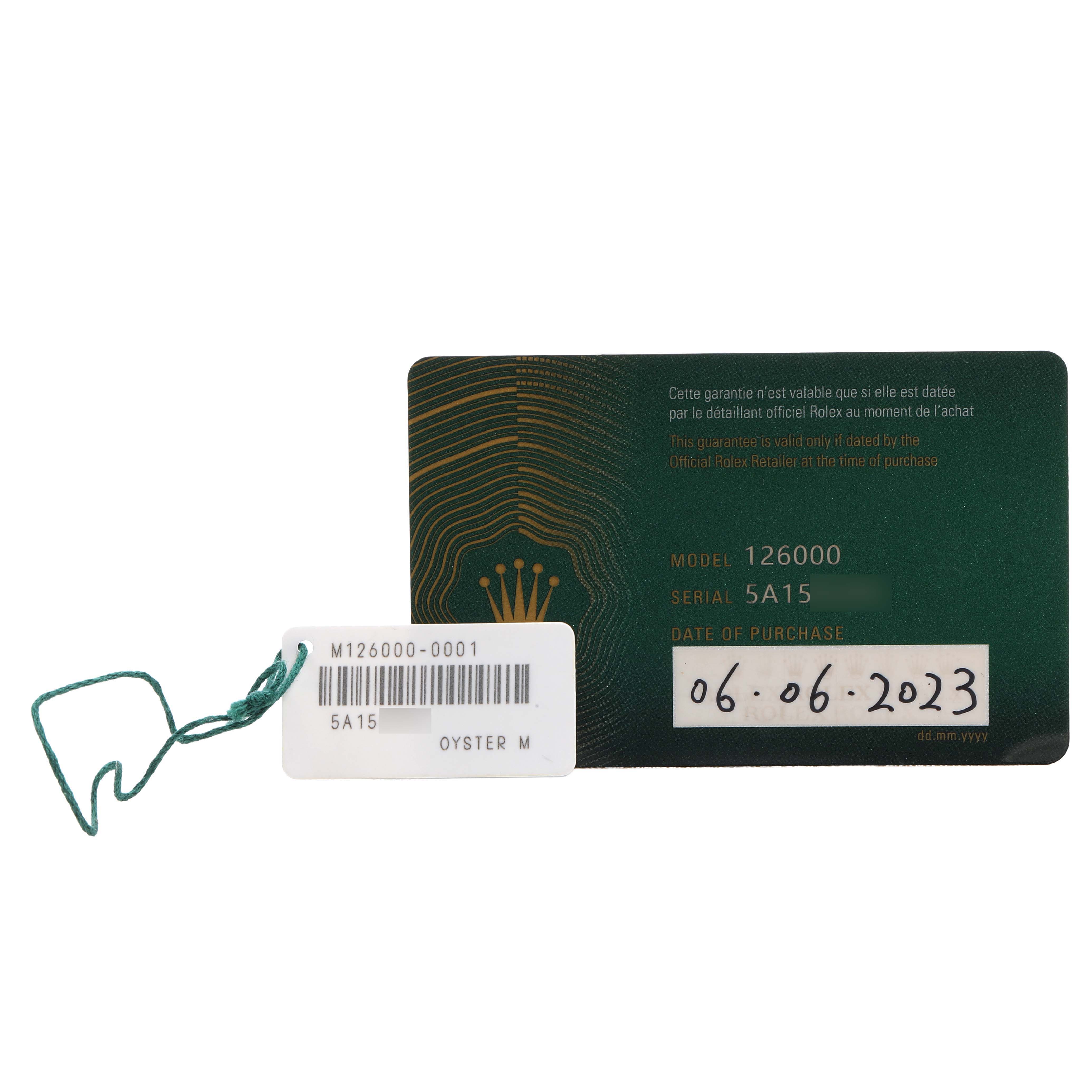 The image shows a Rolex Oyster Perpetual 126000 Men's Stainless Steel Silver Dial model 126000 card and a tag with a barcode and model information.