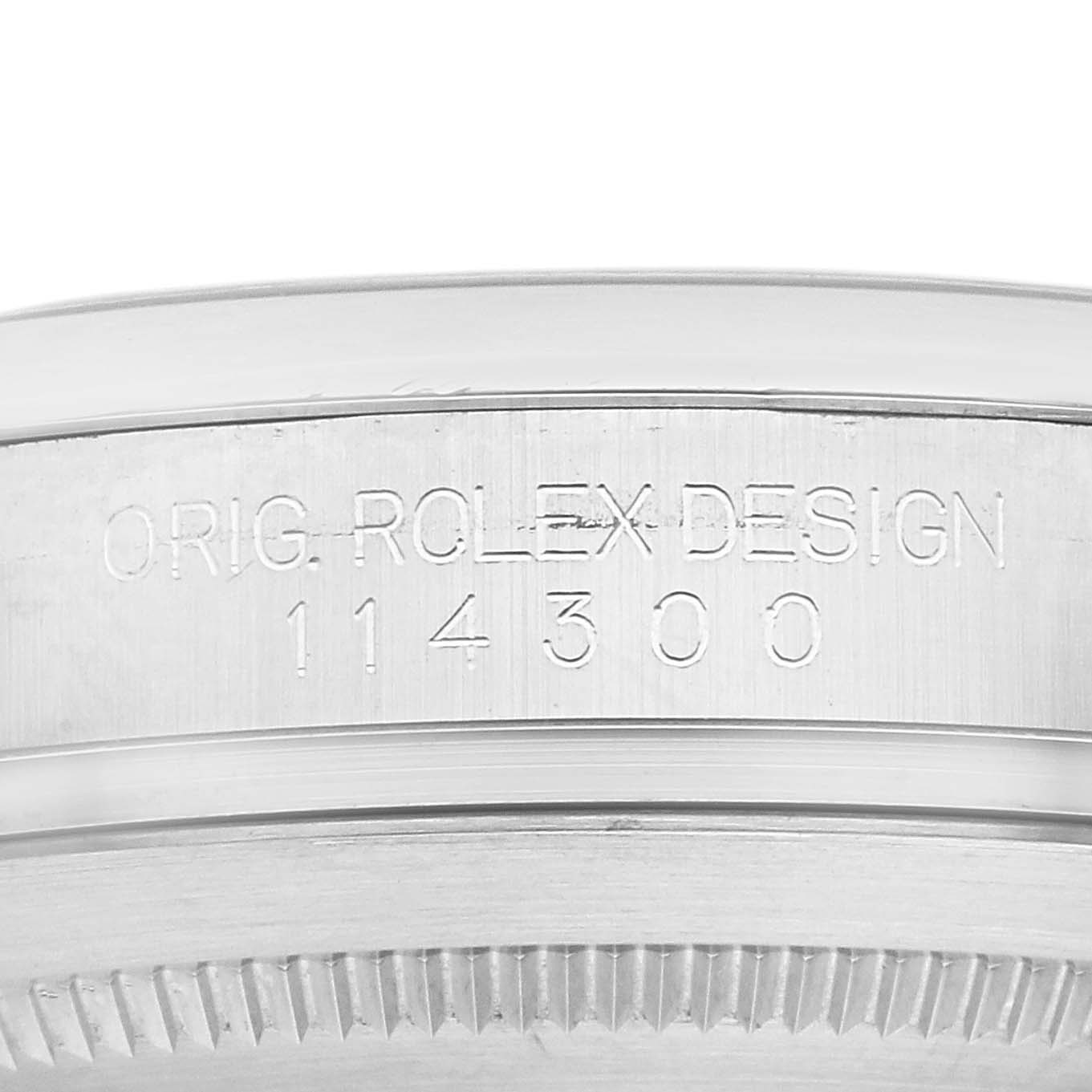 This image shows a close-up of the side of a Rolex Oyster Perpetual 114300 Men's Stainless Steel Grey Dial 114300 Men's Stainless Steel Grey Dial watch, highlighting the engraved model number "114300."