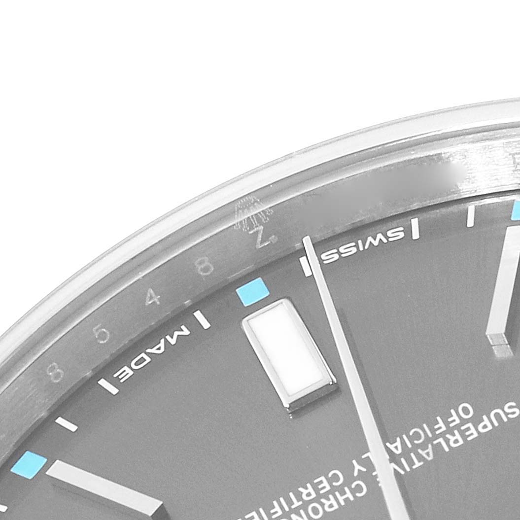 The image shows a close-up of the Rolex Oyster Perpetual 114300 Men's Stainless Steel Grey Dial 114300 Men's Stainless Steel Grey Dial watch dial and bezel from an angled top perspective.