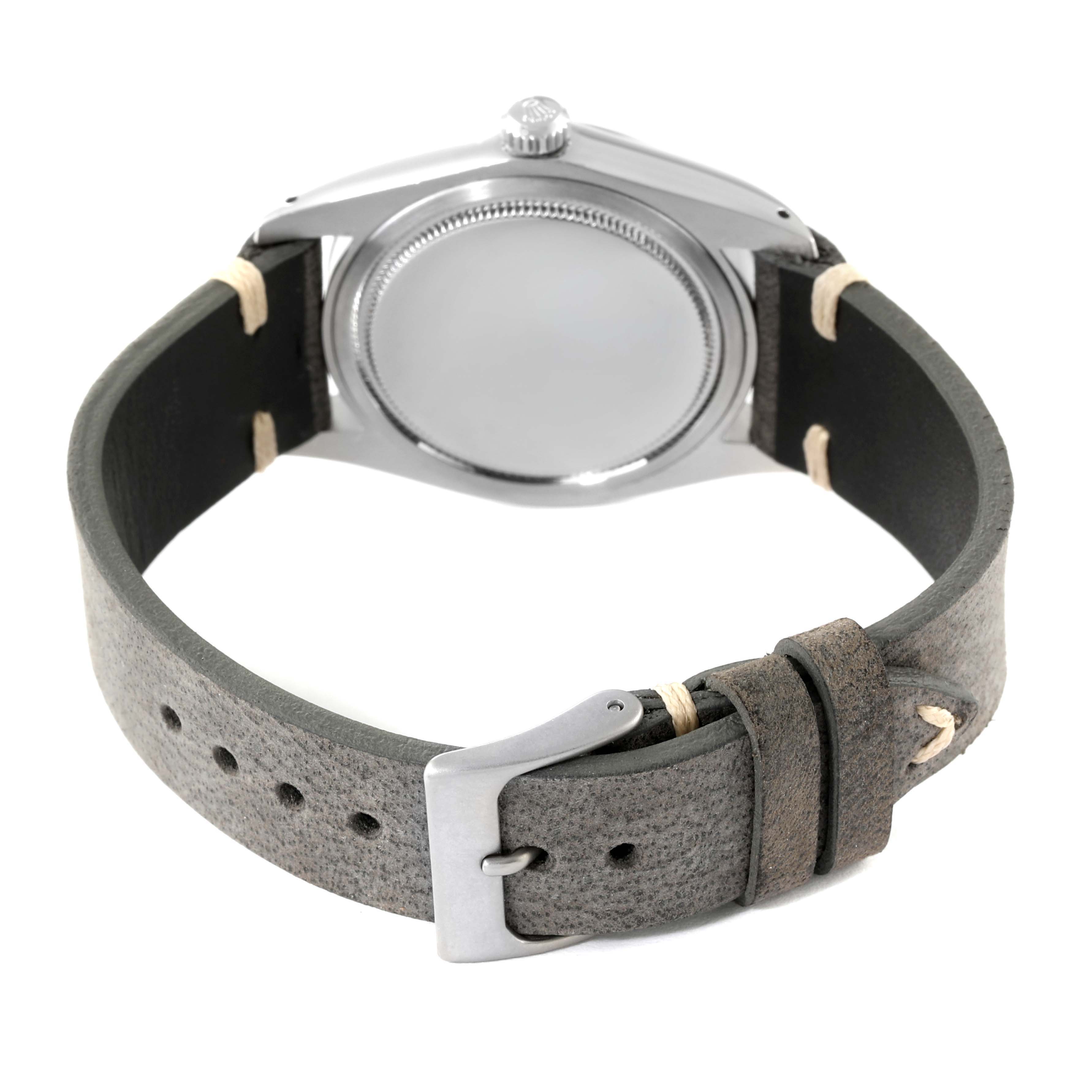 The image shows the back view of a Rolex Date 6694 Men's Stainless Steel Black Dial 6694 Men's Stainless Steel Black Dial model watch with a grey leather strap and metallic buckle.