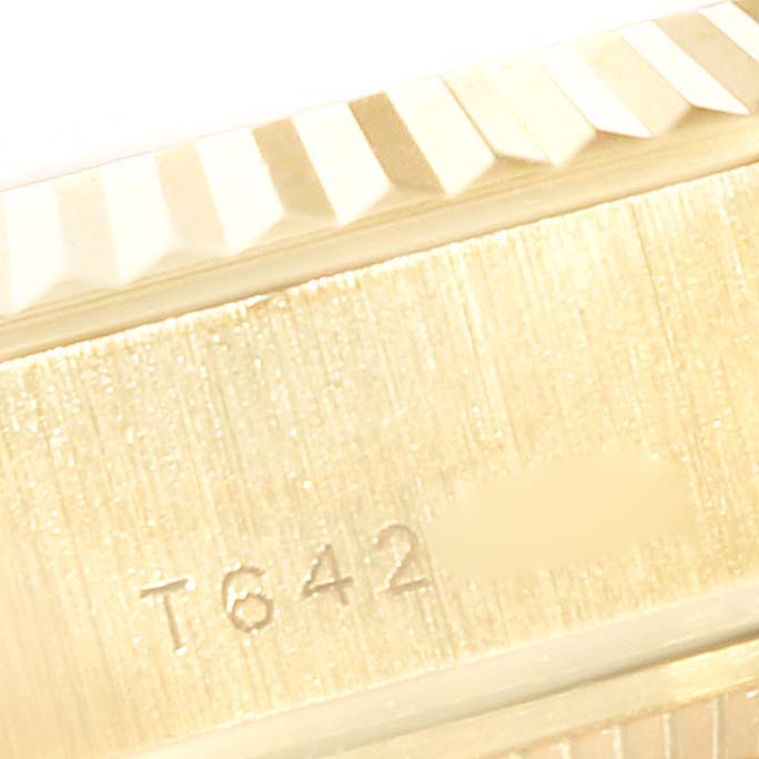 This image shows a close-up of the serial number and fluted bezel of a President model by Rolex.