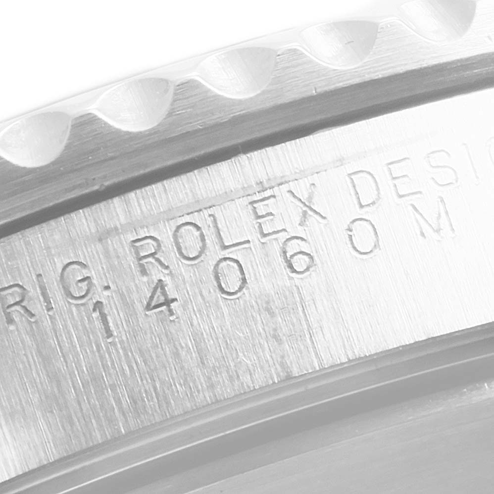 This image shows an up-close view of the Rolex Submariner 14060M Men
s Stainless Steel Black Dial 14060M Men
s Stainless Steel Black Dial model
s engraved case back edge and part of the bezel.
