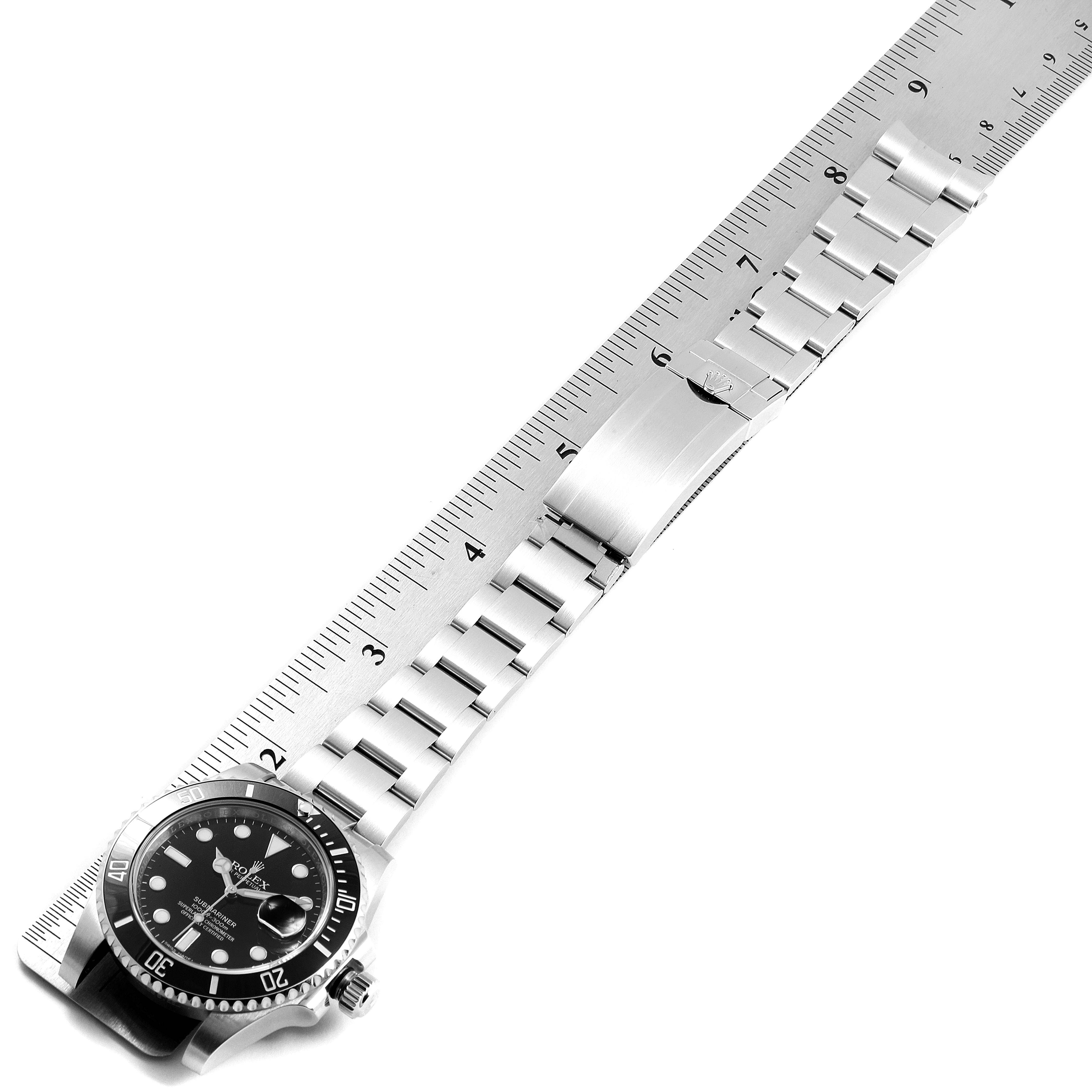 The image shows a Rolex Submariner 116610 Men
s Stainless Steel Black Dial 116610 Men
s Stainless Steel Black Dial laid flat with its bracelet extended and measured against a metallic ruler.