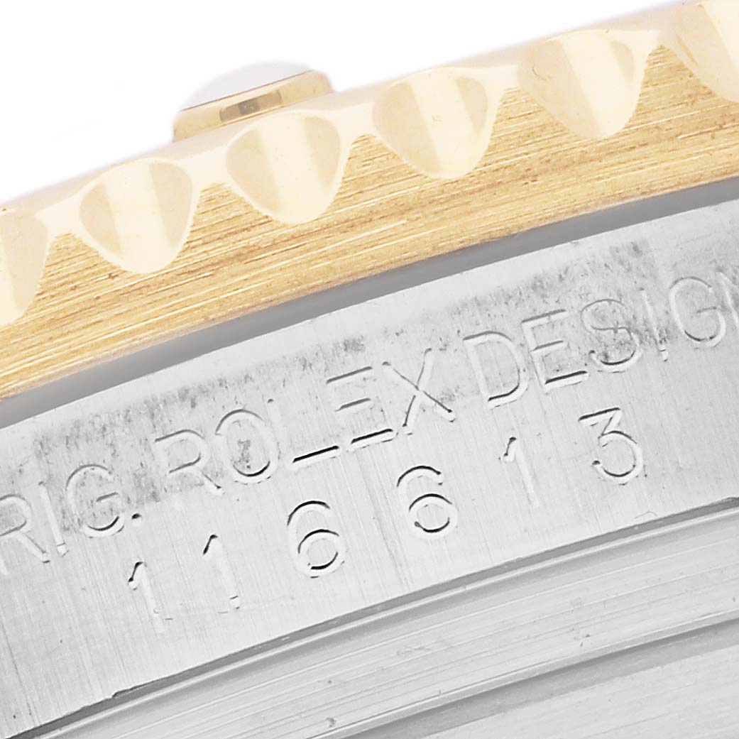 The image shows an angled close-up of the side of a Rolex Submariner 116613 Men's Steel and Gold (two tone) Blue Dial 116613 Men's Steel and Gold (two tone) Blue Dial watch, highlighting its serial number and part of the bezel.