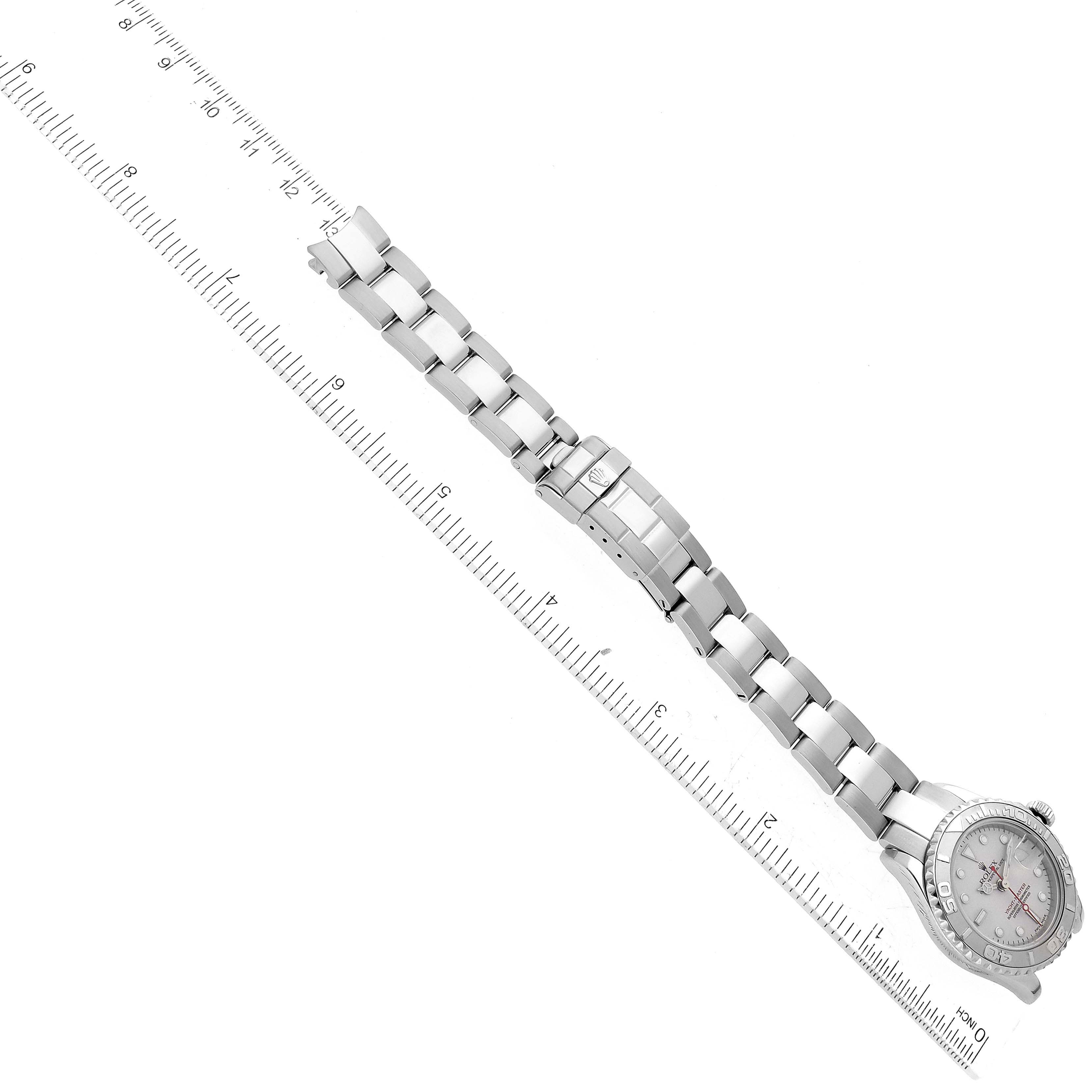 The Rolex Yacht-Master 169622 Women
s Stainless Steel Silver Dial 169622 Women
s Stainless Steel Silver Dial watch is pictured at an angle, showing the face, bezel, and full metal bracelet alongside a ruler for scale.