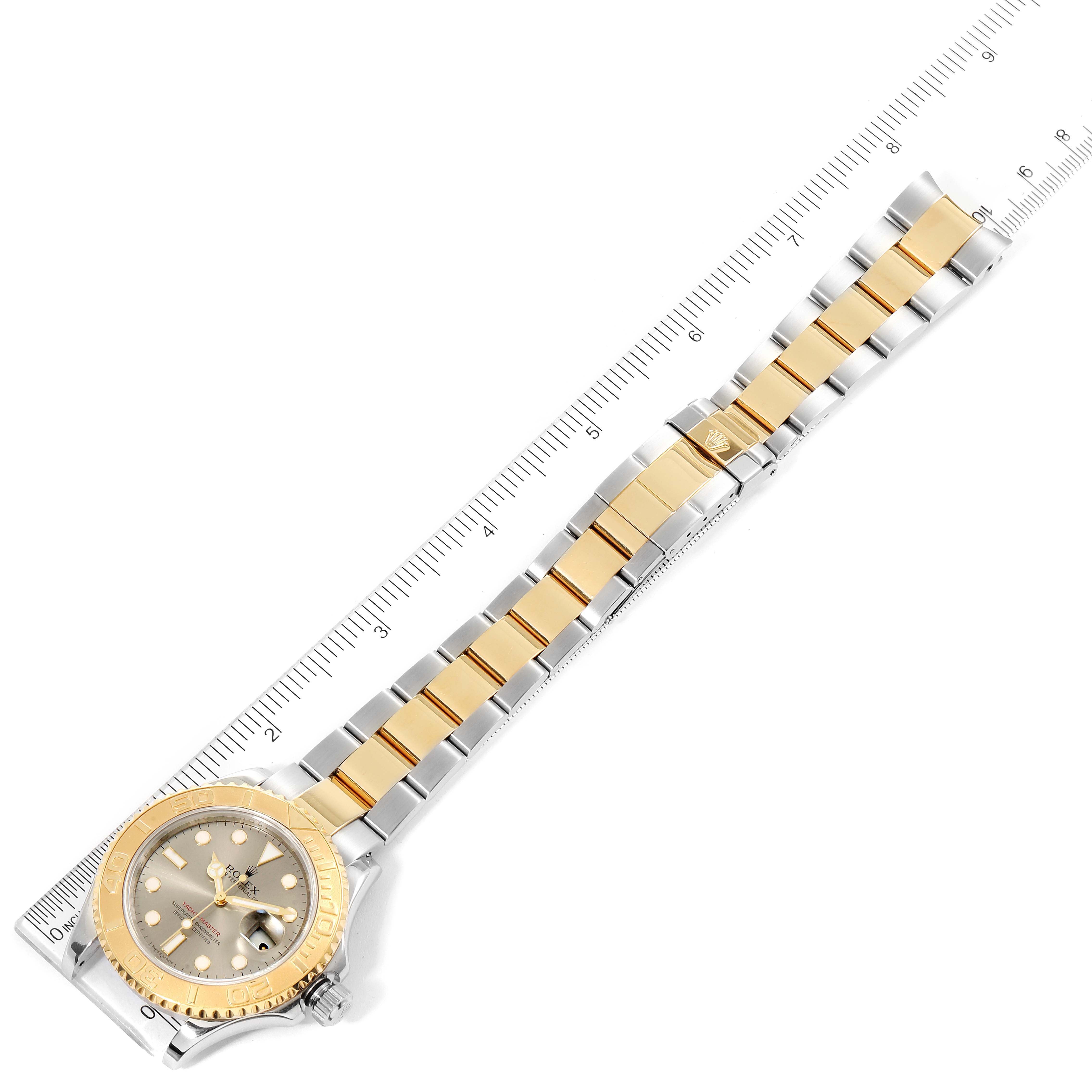 The Rolex Yacht-Master 16623 Men
s Steel and Gold (two tone) Grey Dial 16623 Men
s Steel and Gold (two tone) Grey Dial watch is shown from an aerial view, highlighting the full strap and face against a measurement ruler.