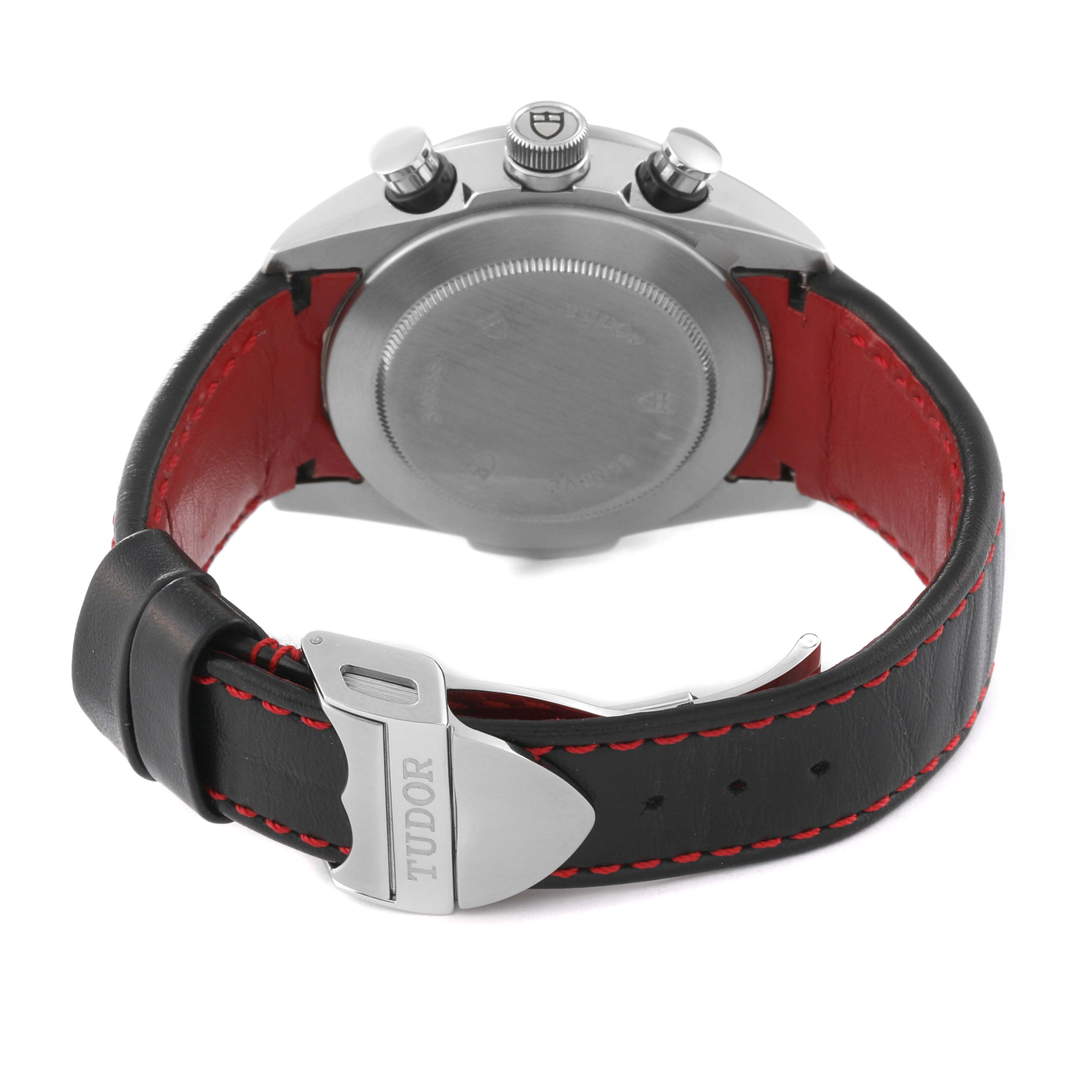 The image shows the back of a Tudor Fastrider 42000D Men's Stainless Steel Red Dial 42000D Men's Stainless Steel Red Dial watch and its strap with a buckle displaying the Tudor logo.