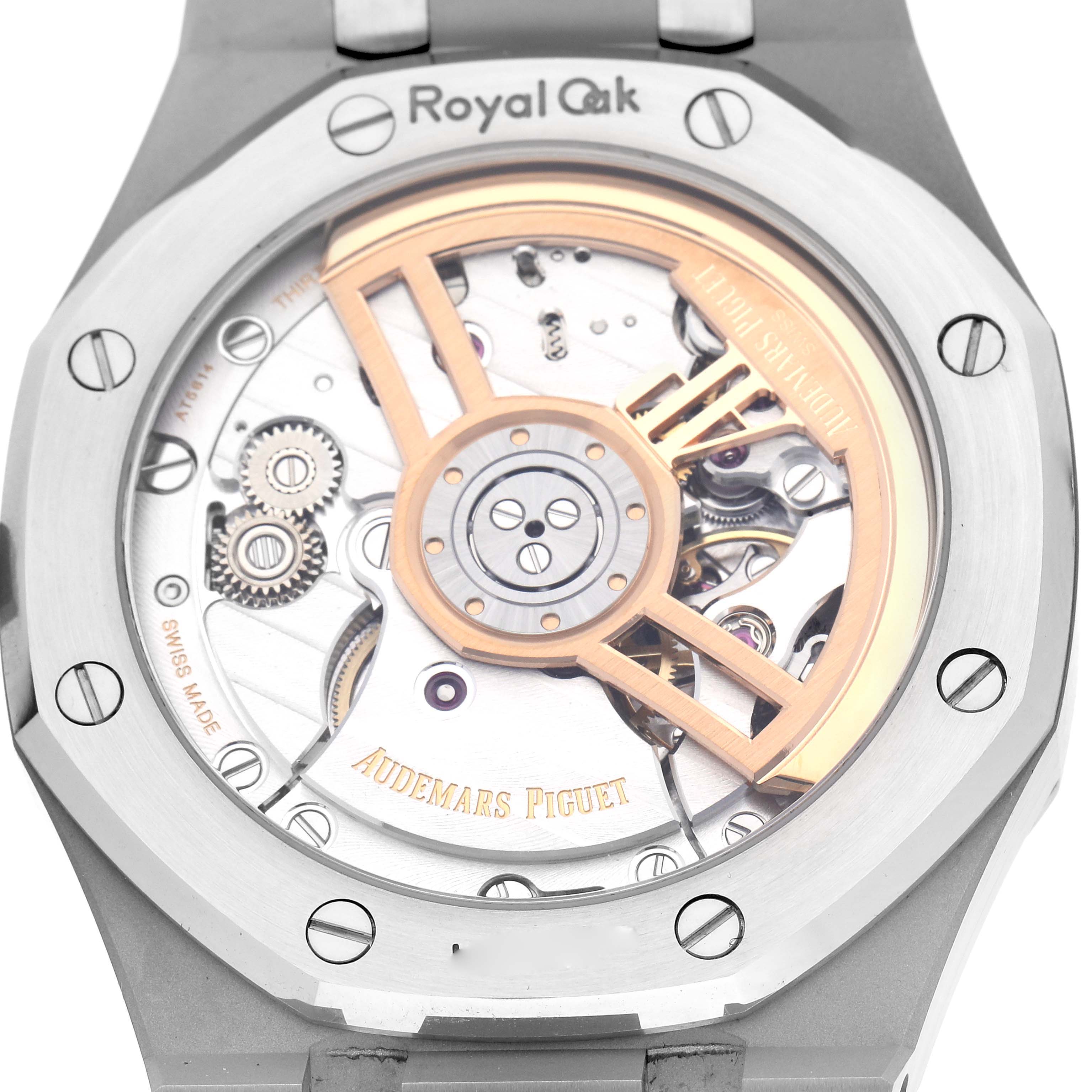 The image shows the back view of a Royal Oak by Audemars Piguet, highlighting the intricate movement and rotor.