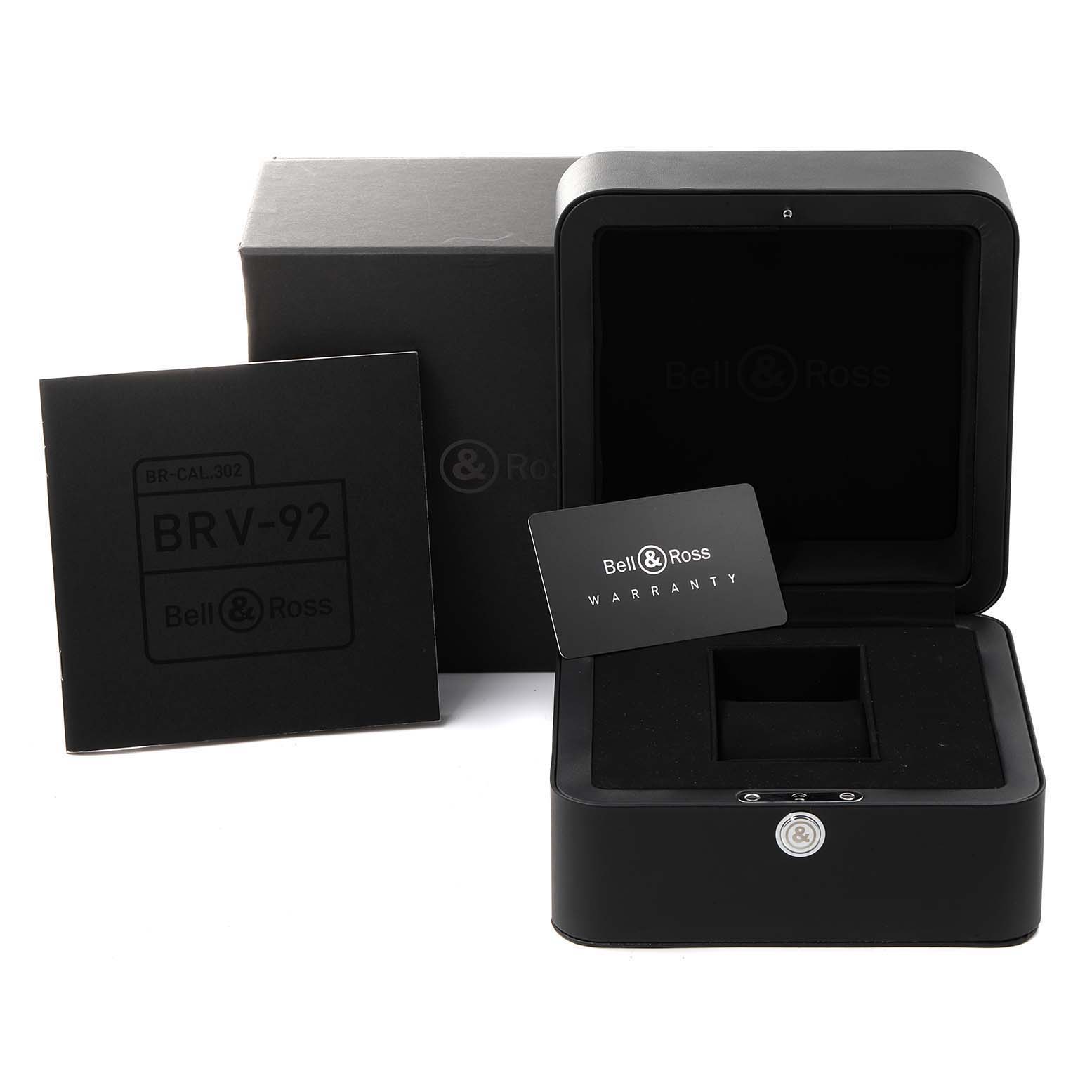 The image shows packaging and accessories for the Bell & Ross Heritage BRV292-BU-G-ST/SCA Men's Stainless Steel Blue Dial BRV292-BU-G-ST/SCA Men's Stainless Steel Blue Dial BRV-92, including a box, instruction booklet, and warranty card.