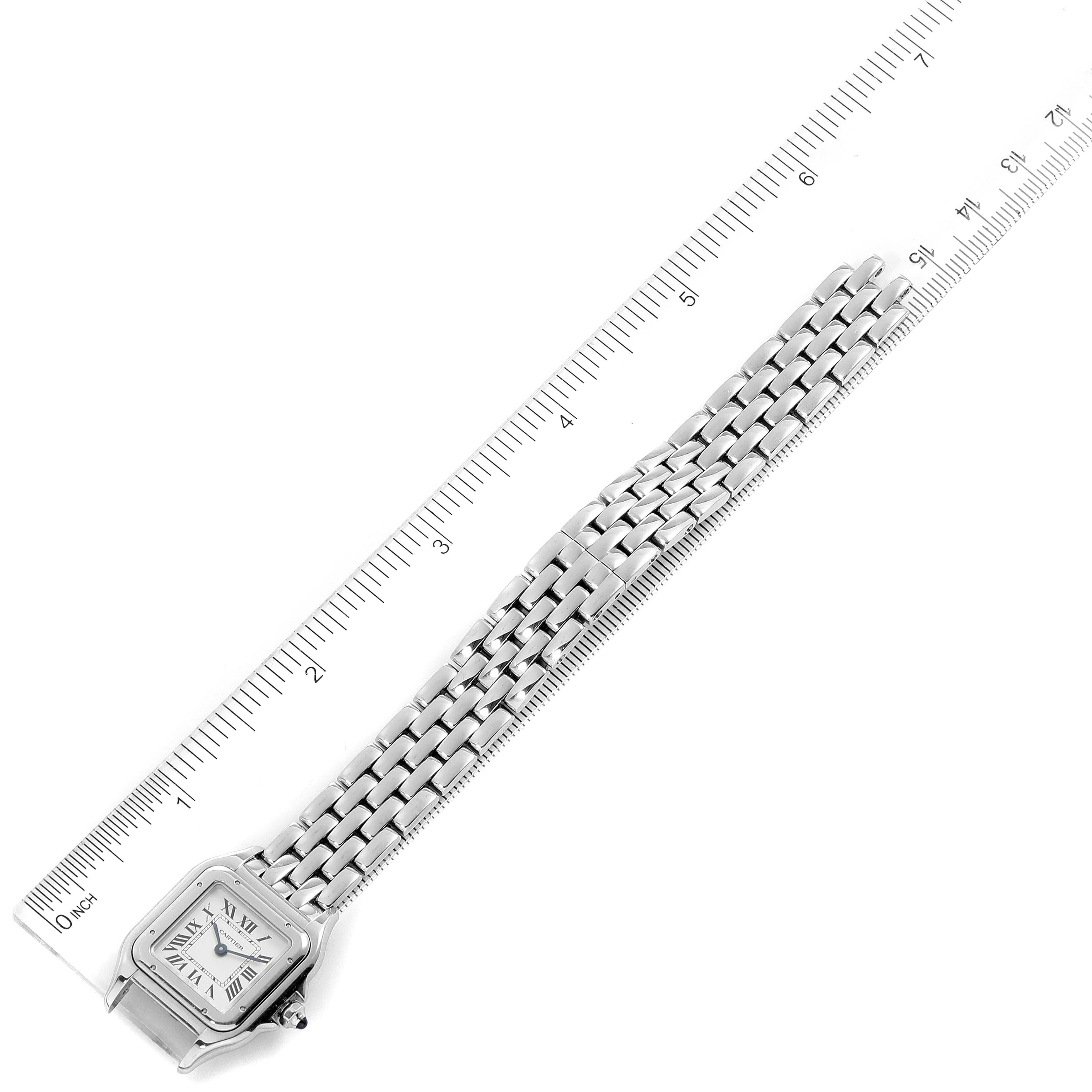 The image shows a Panthere model watch by Cartier laid flat alongside a ruler, displaying its face and full metal band.