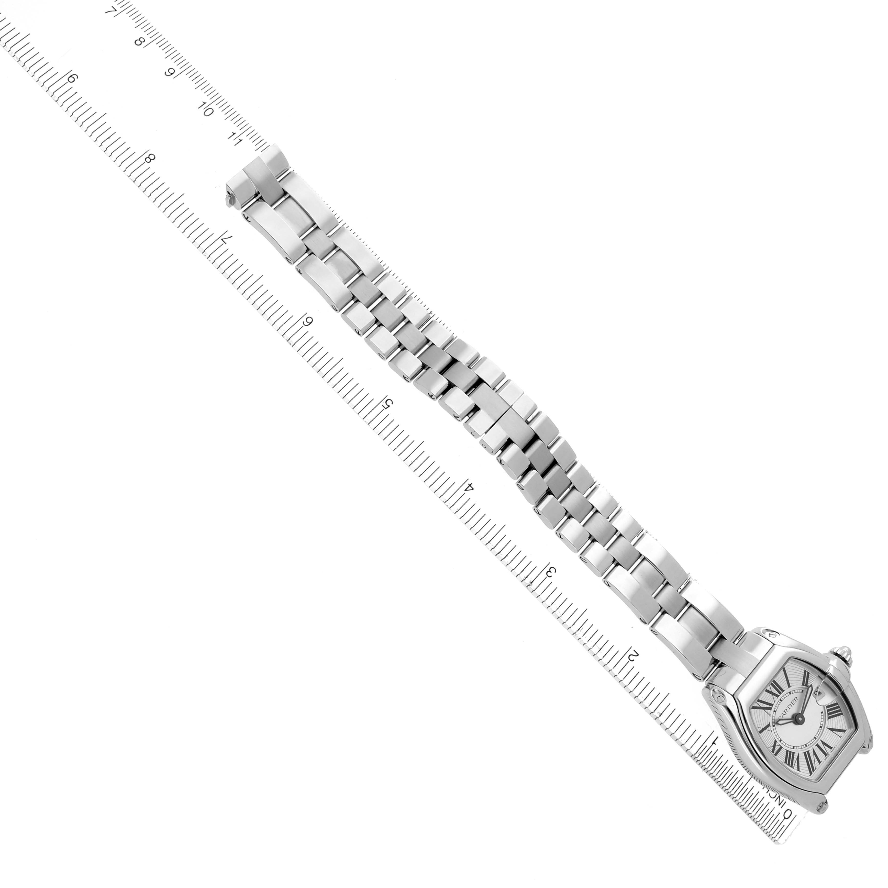 The Cartier Roadster W62016V3 Women
s Stainless Steel Silver Dial W62016V3 Women
s Stainless Steel Silver Dial watch is shown at an angle, displaying the full bracelet and face next to a ruler.