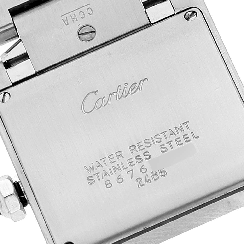 The image shows the back of a Cartier Tank Française watch, displaying engravings indicating water resistance and stainless steel construction.