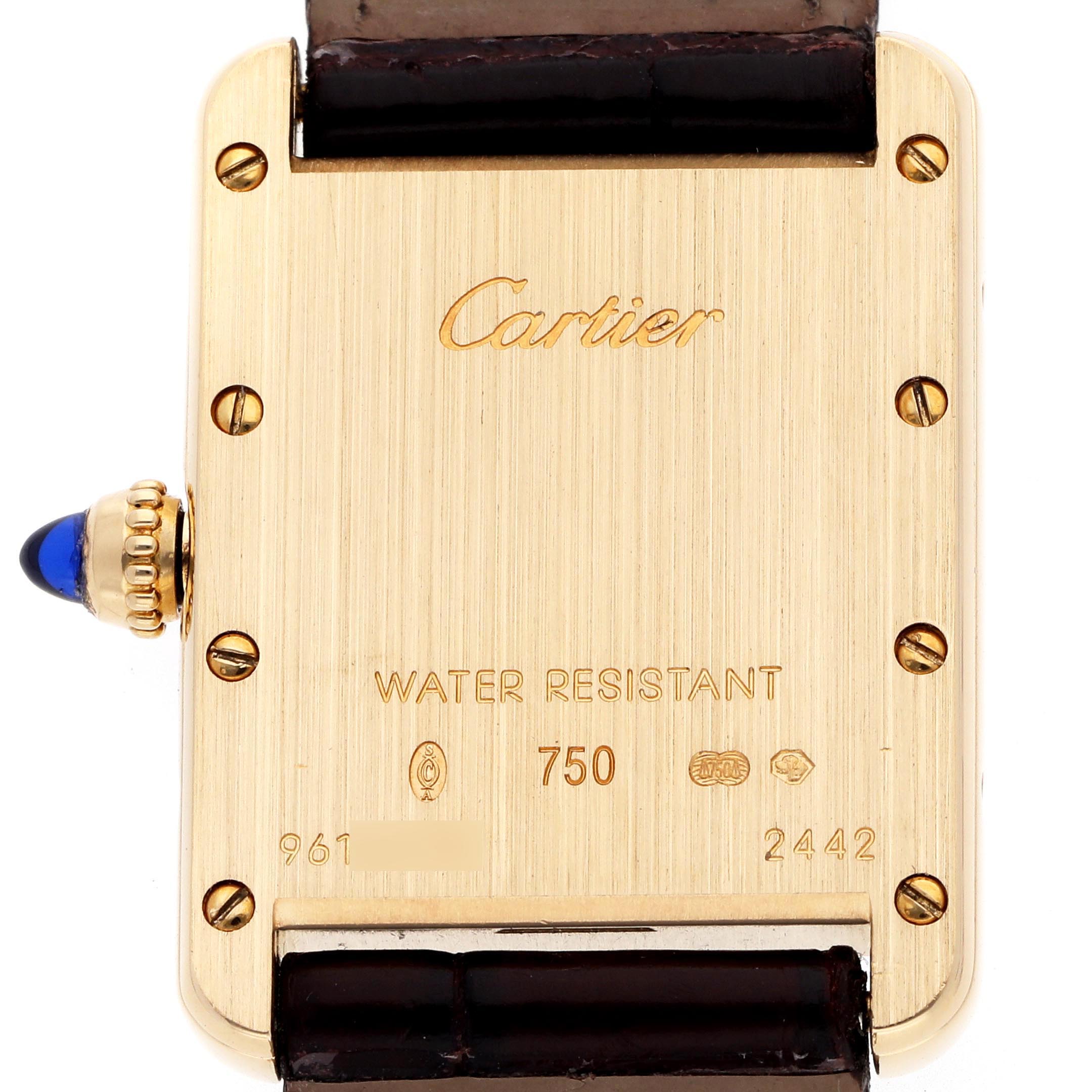 The image shows the back of a Cartier Tank Louis W1529856 Women
s Yellow Gold Silver Dial W1529856 Women
s Yellow Gold Silver Dial watch, highlighting its branded engravings and a sapphire cabochon crown.
