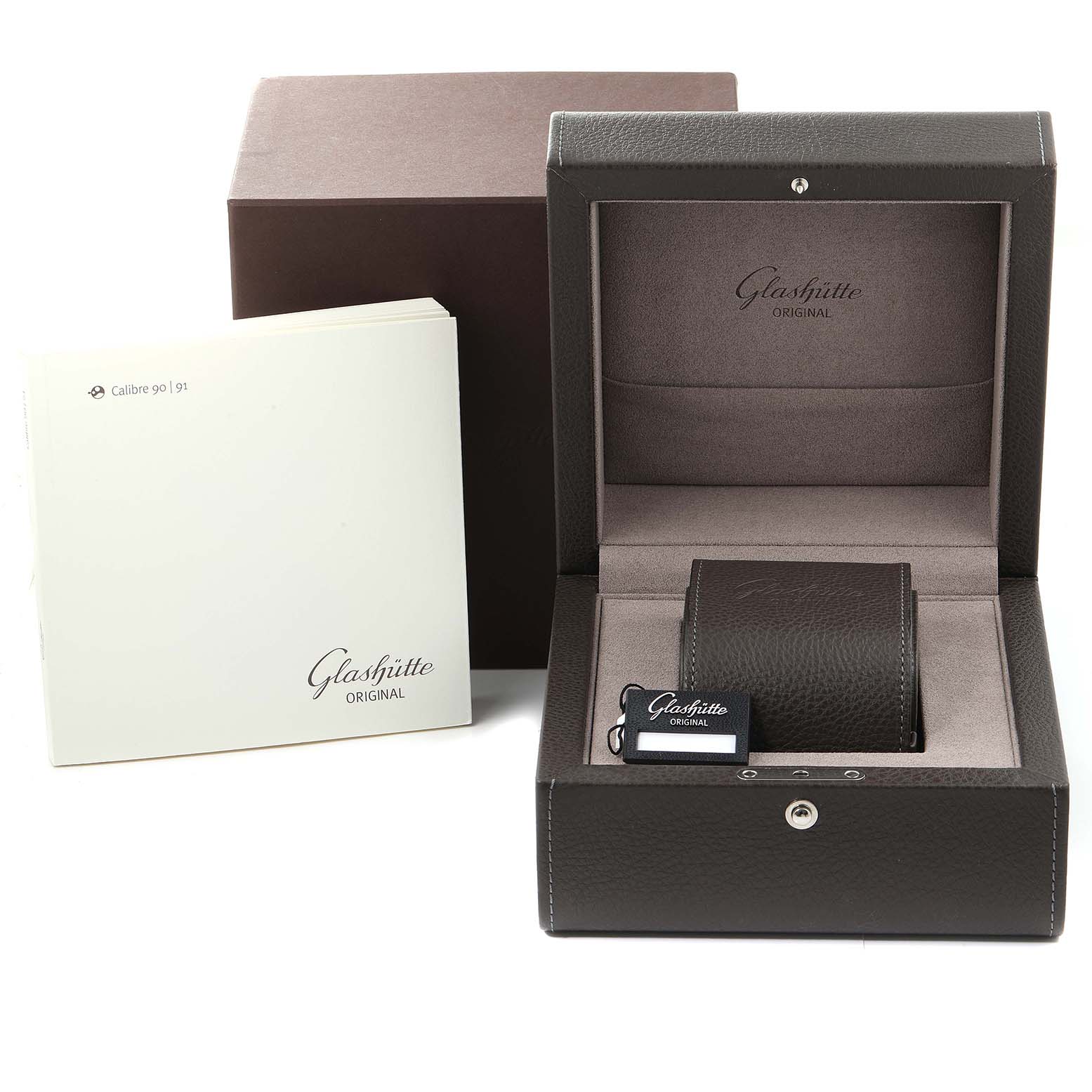 The image shows the packaging and accessories of a Glashütte Pano model watch, including a box, booklet, and watch pillow.