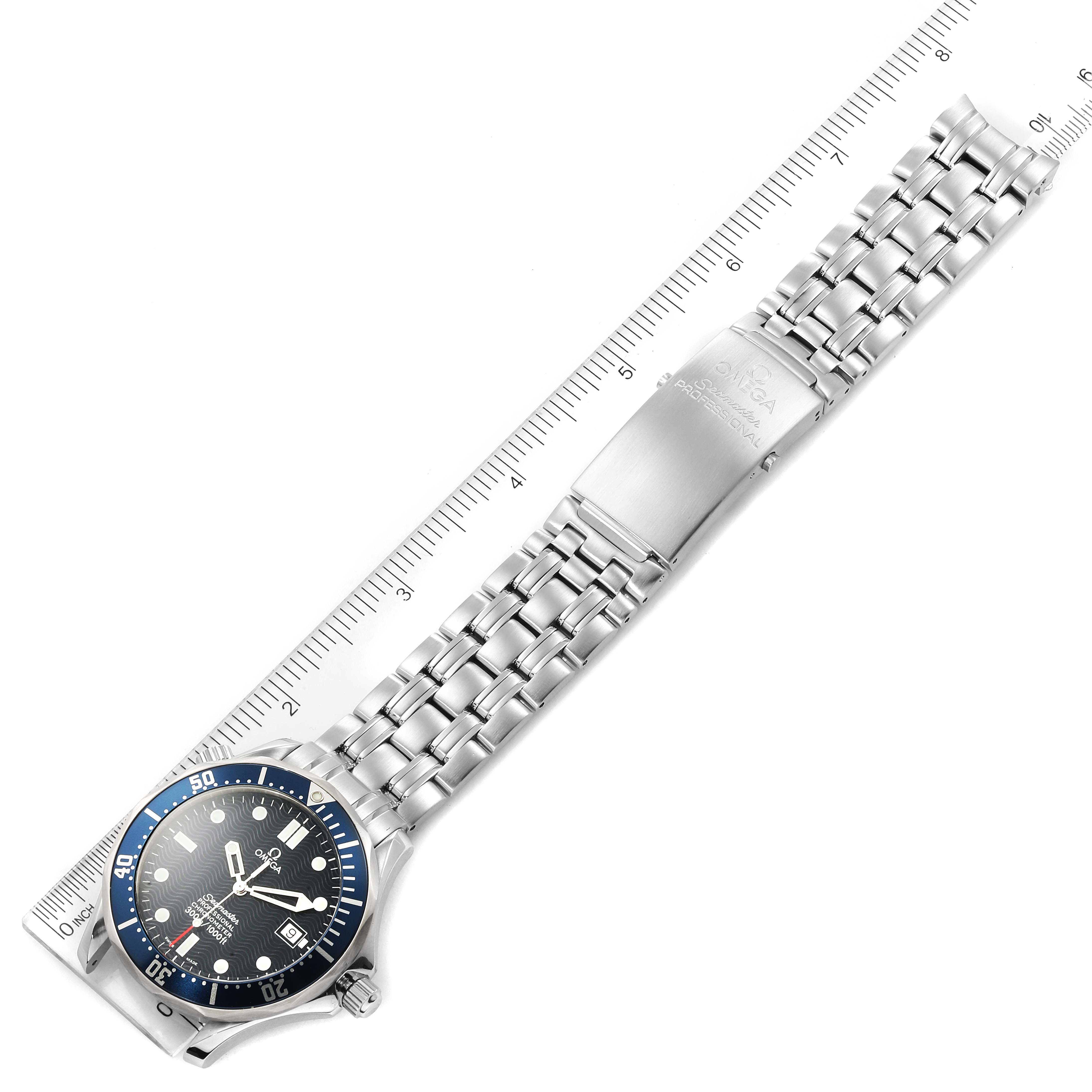 The Omega Seamaster 2531.80.00 Men
s Stainless Steel Blue Dial 2531.80.00 Men
s Stainless Steel Blue Dial watch is shown from a top-down angle, displaying its face and metal bracelet alongside a ruler.