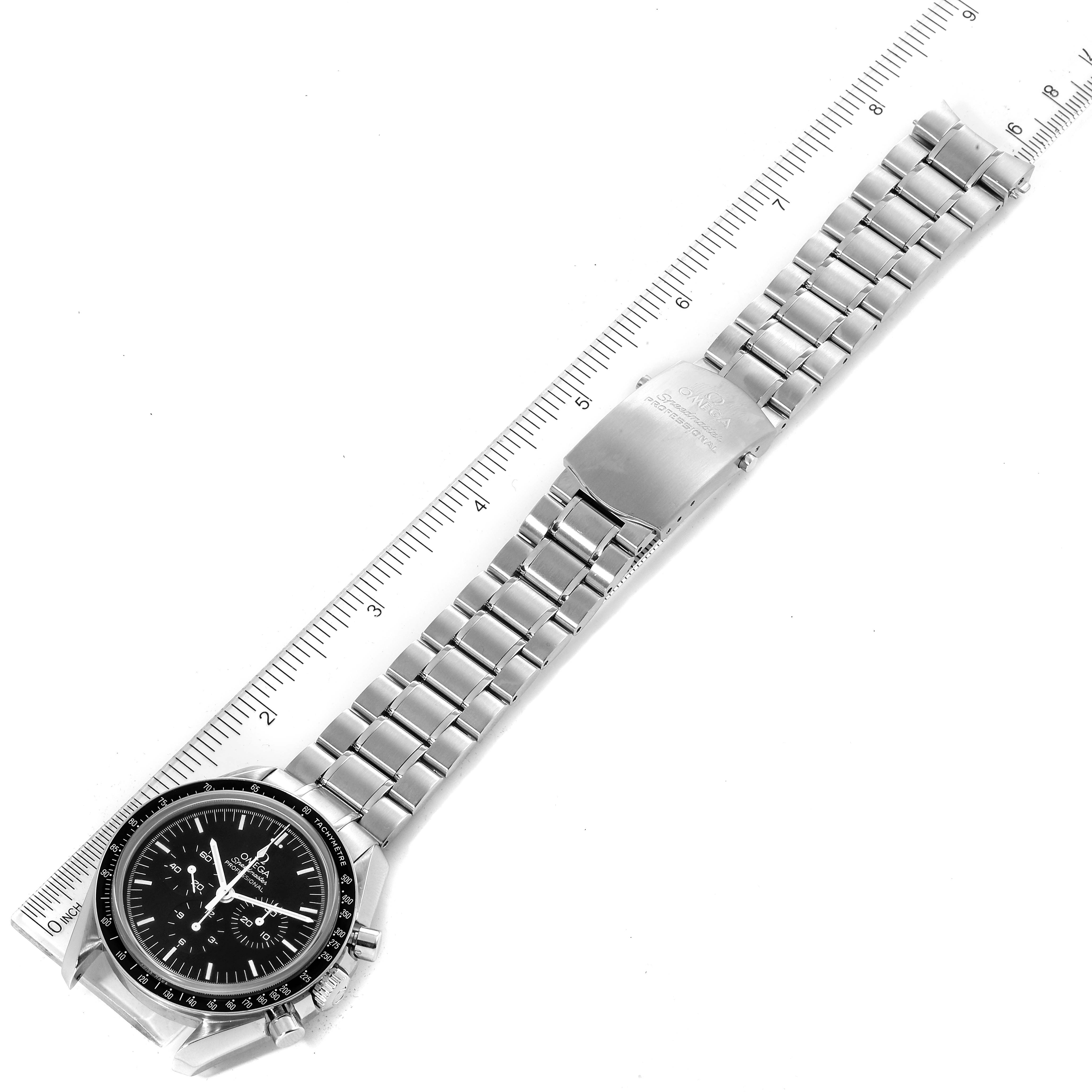The Omega Speedmaster 311.30.42.30.01.006 Men
s Stainless Steel Black Dial 311.30.42.30.01.006 Men
s Stainless Steel Black Dial watch is shown in an overhead view with its full metal bracelet aligned against a ruler.