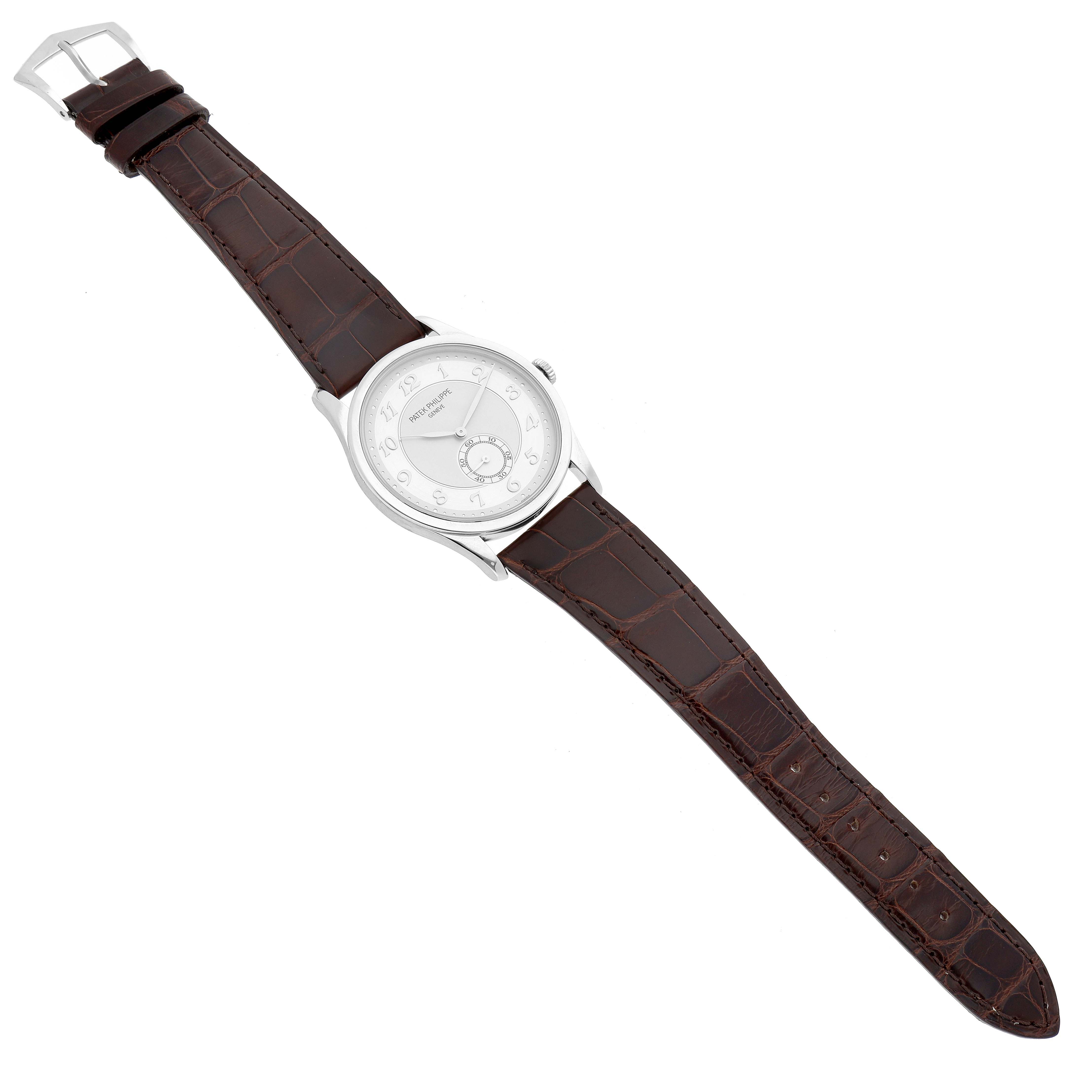 The Patek Philippe Calatrava 5196P-001 Men's Platinum Silver Dial watch is shown from a top-down angle, displaying its round dial and full leather strap.