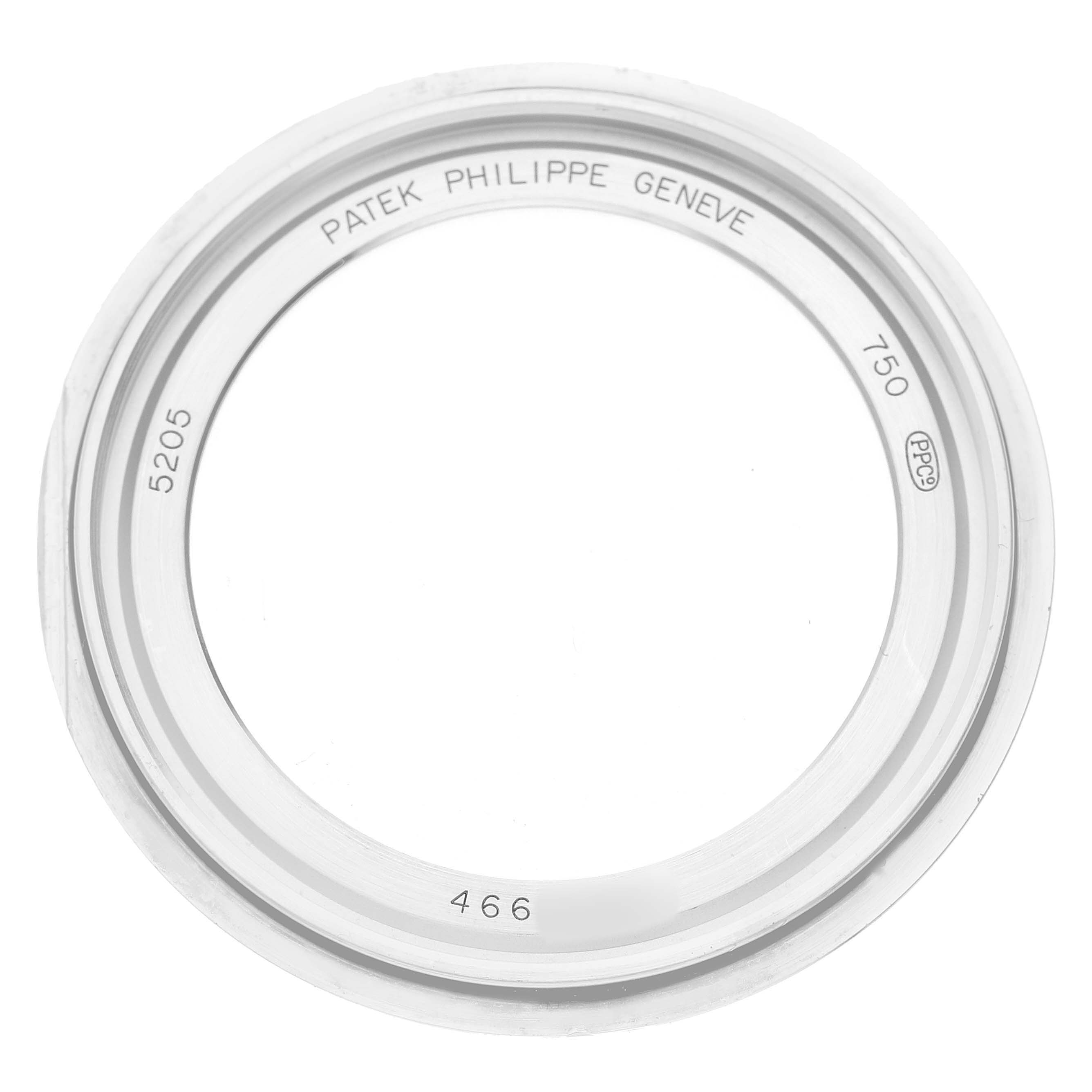 The image shows a top view of a Patek Philippe Complications 5205G-010 Men's White Gold Grey Dial model bezel, featuring model number and branding engravings.