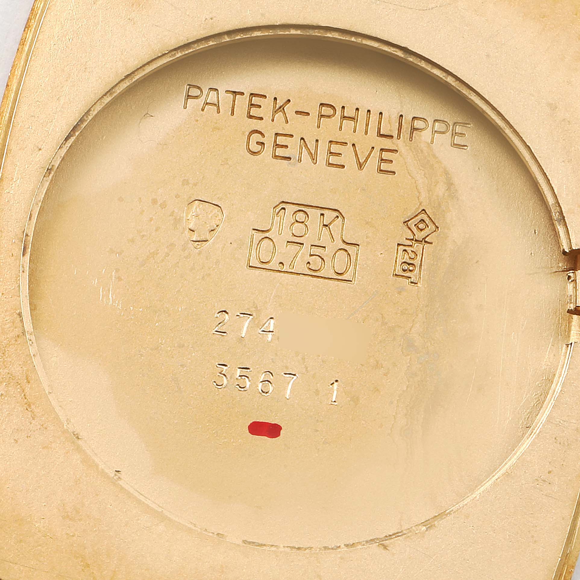 This image shows the inner case back of a vintage Patek Philippe watch, displaying hallmarks and engravings indicating 18K gold.
