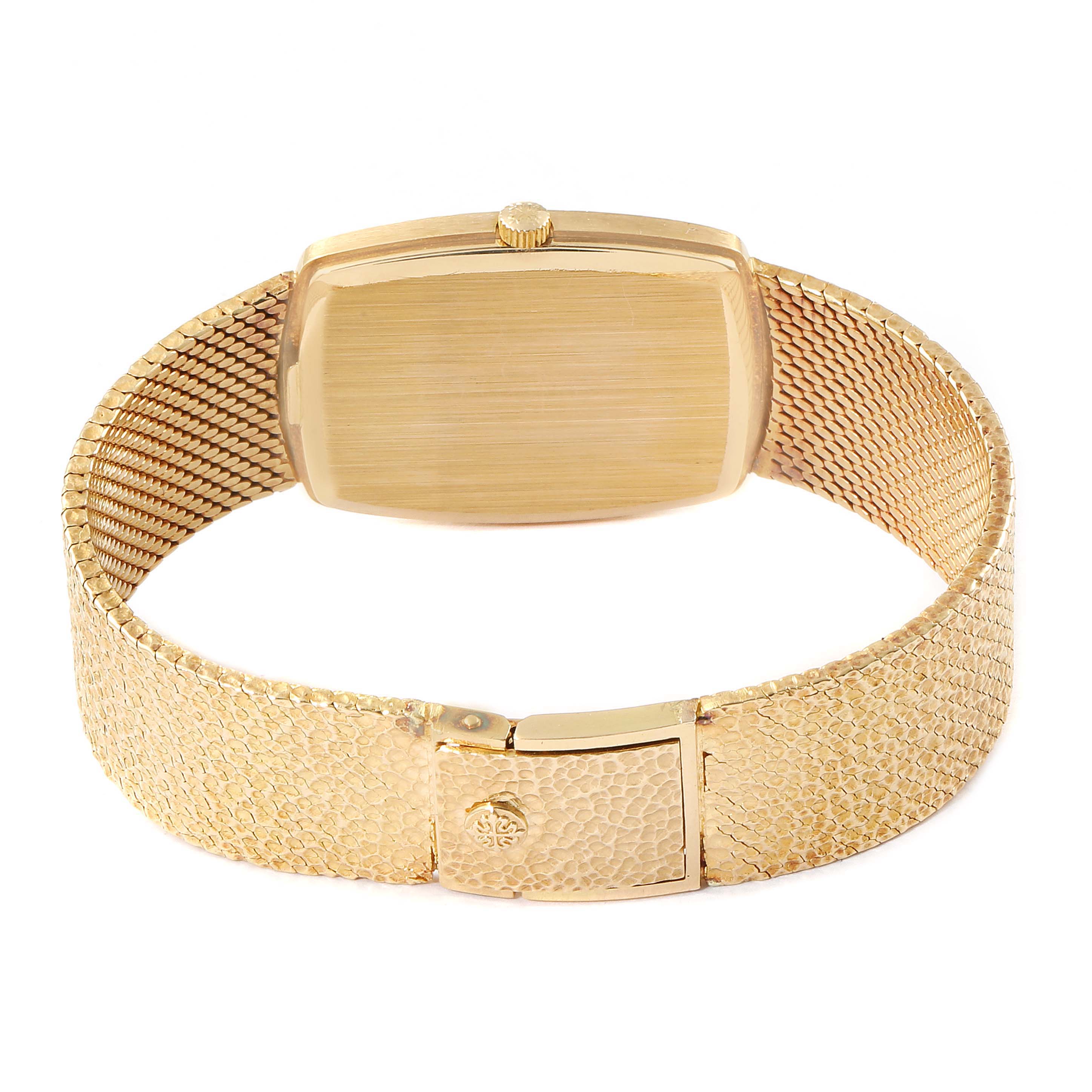 The image shows the back view of a Vintage Patek Philippe watch, featuring its case, crown, and textured gold bracelet.