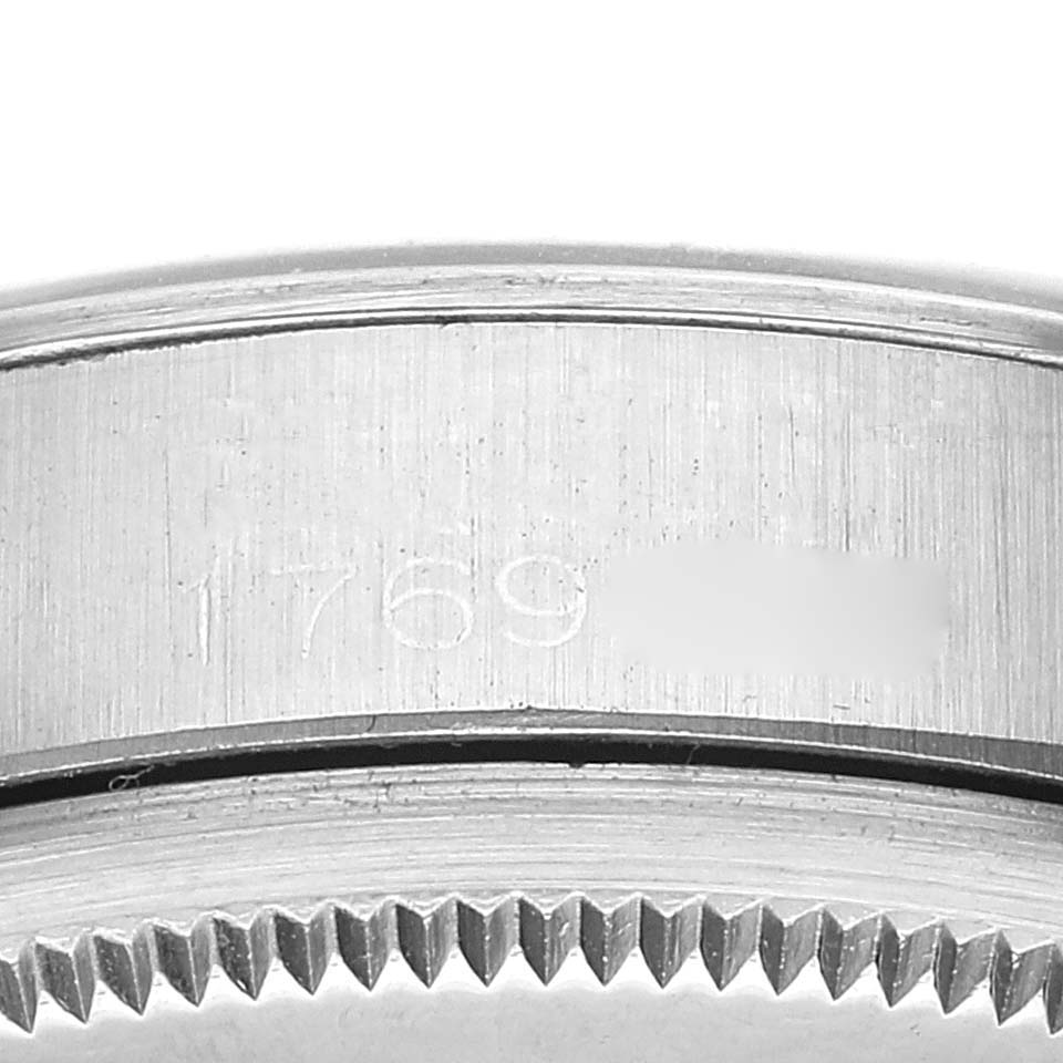 This close-up angle of a Rolex Date 1500 Men's Stainless Steel Silver Dial 1500 Men's Stainless Steel Silver Dial model watch shows the case's edge with engraved serial numbers.