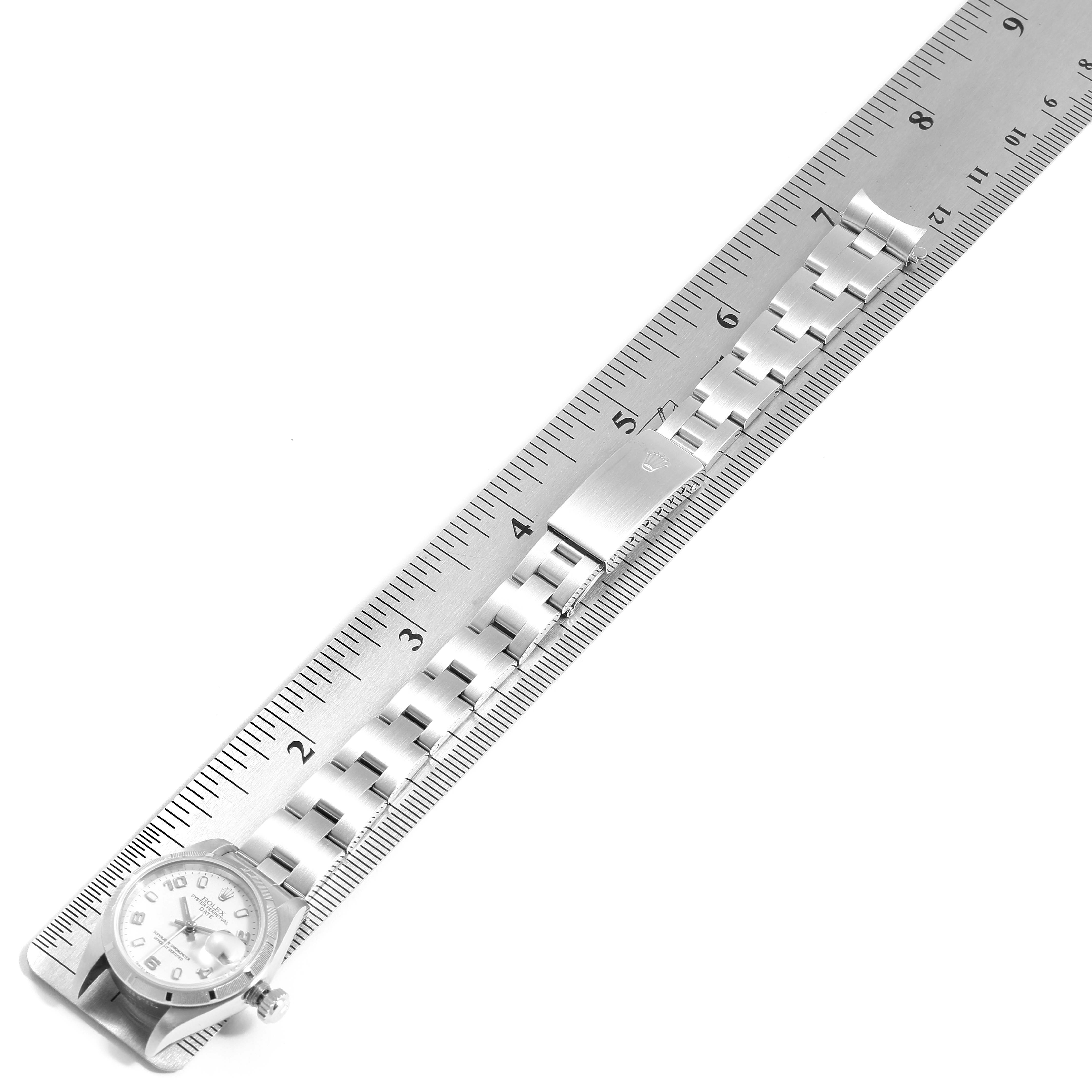 The image shows a Rolex Date 79190 Women
s Stainless Steel White Dial 79190 Women
s Stainless Steel White Dial model watch laid flat with its bracelet stretched out, measured using a metal ruler.