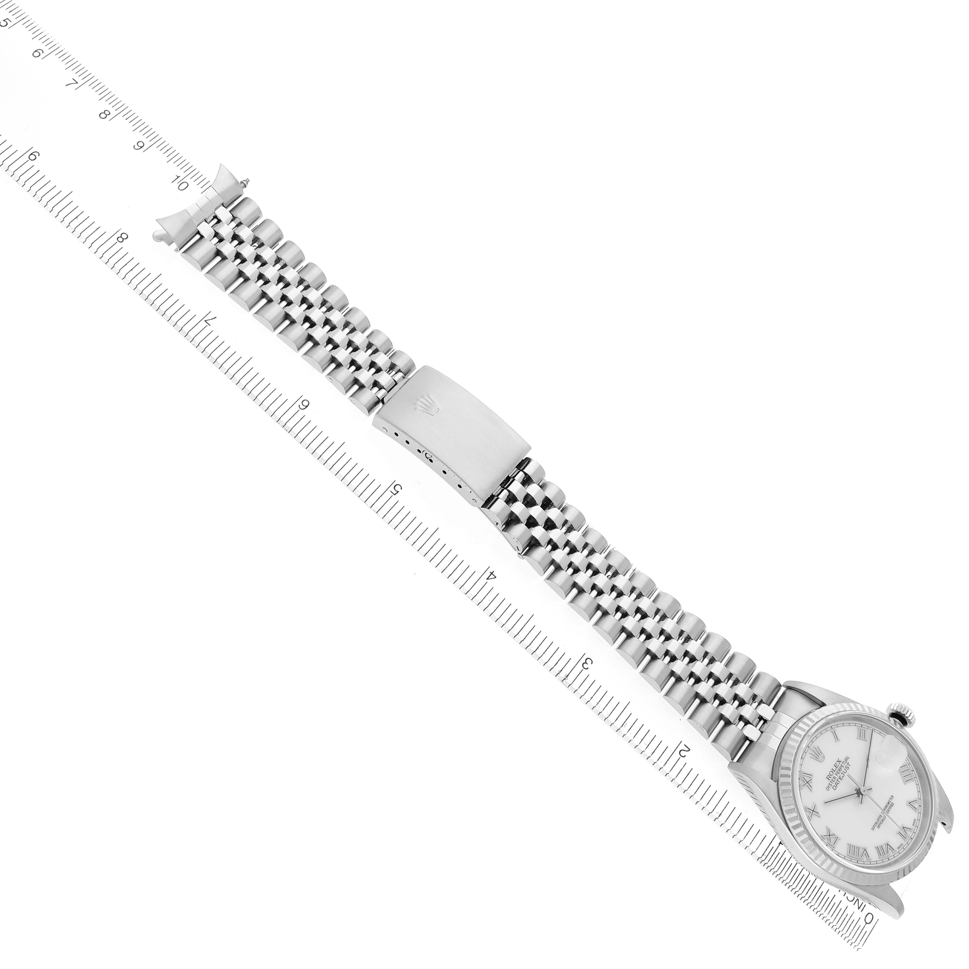 The Rolex Datejust 16234 Men's Stainless Steel White Dial 16234 Men's Stainless Steel White Dial watch is shown from the top, displaying the full bracelet, clasp, and face alongside a ruler.