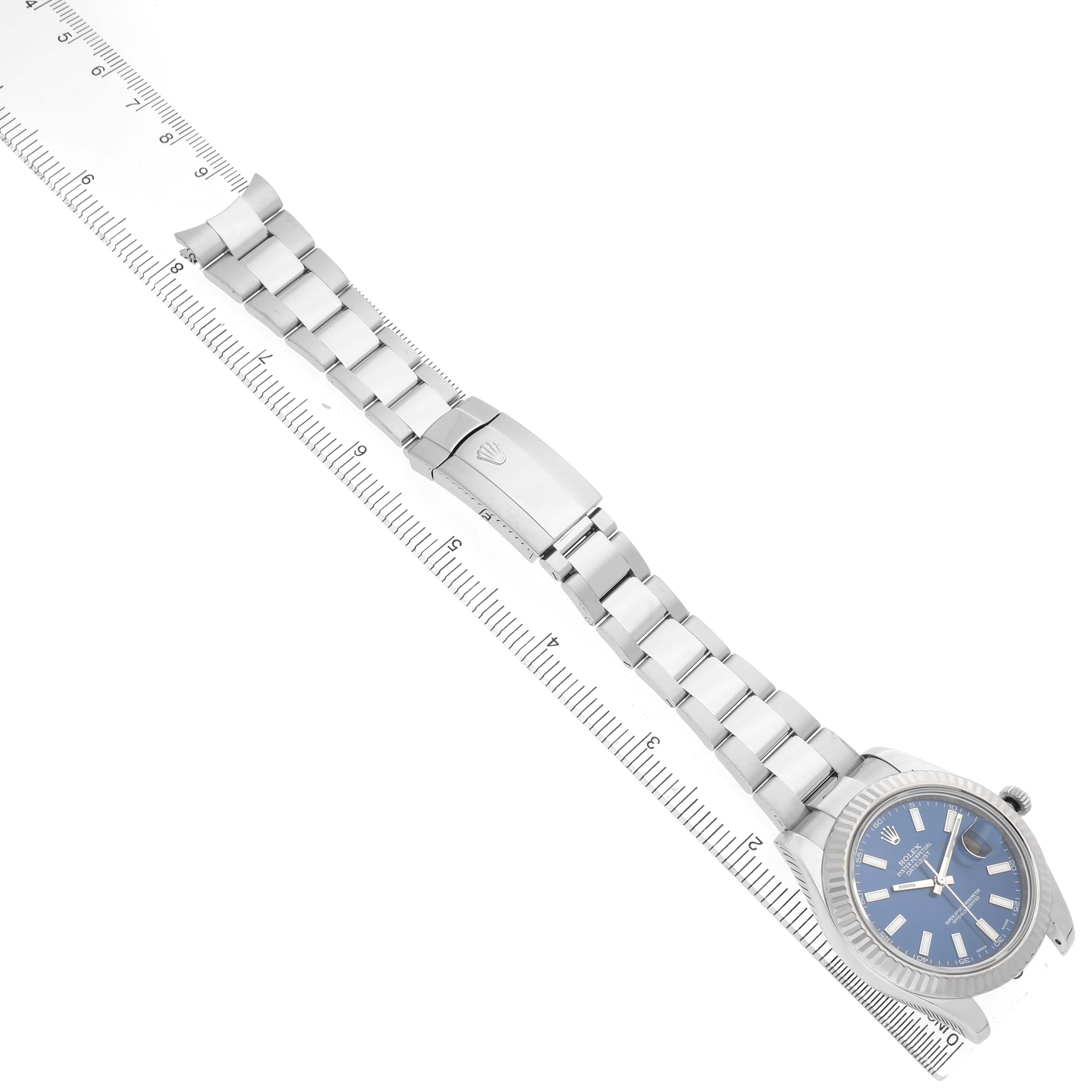 The image shows a Rolex Datejust 41 116334 Men's Stainless Steel Blue Dial watch laid flat, highlighting the bracelet, clasp, and blue dial with a ruler for scale.