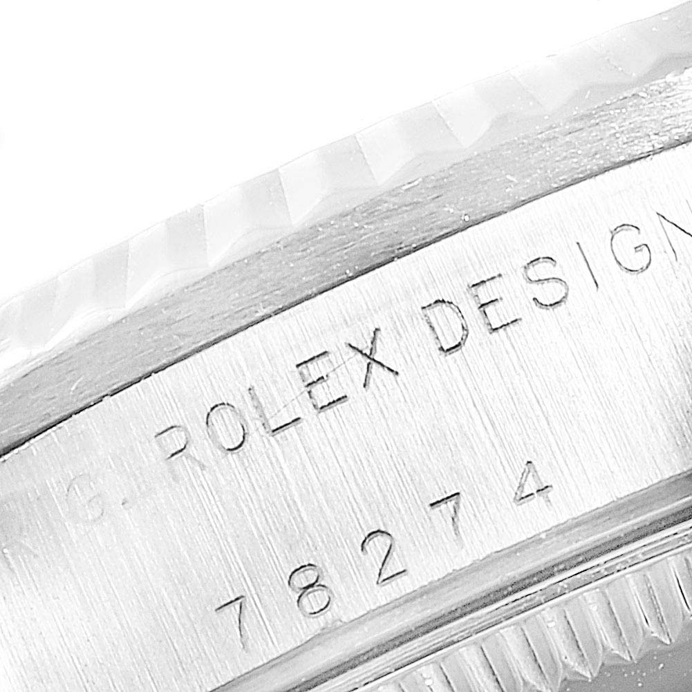 The image shows a close-up angle of the side of a Rolex Mid-Size 78274 Women
s Stainless Steel White Dial 78274 Women
s Stainless Steel White Dial model watch, highlighting the "Rolex Design" engraving and serial number.