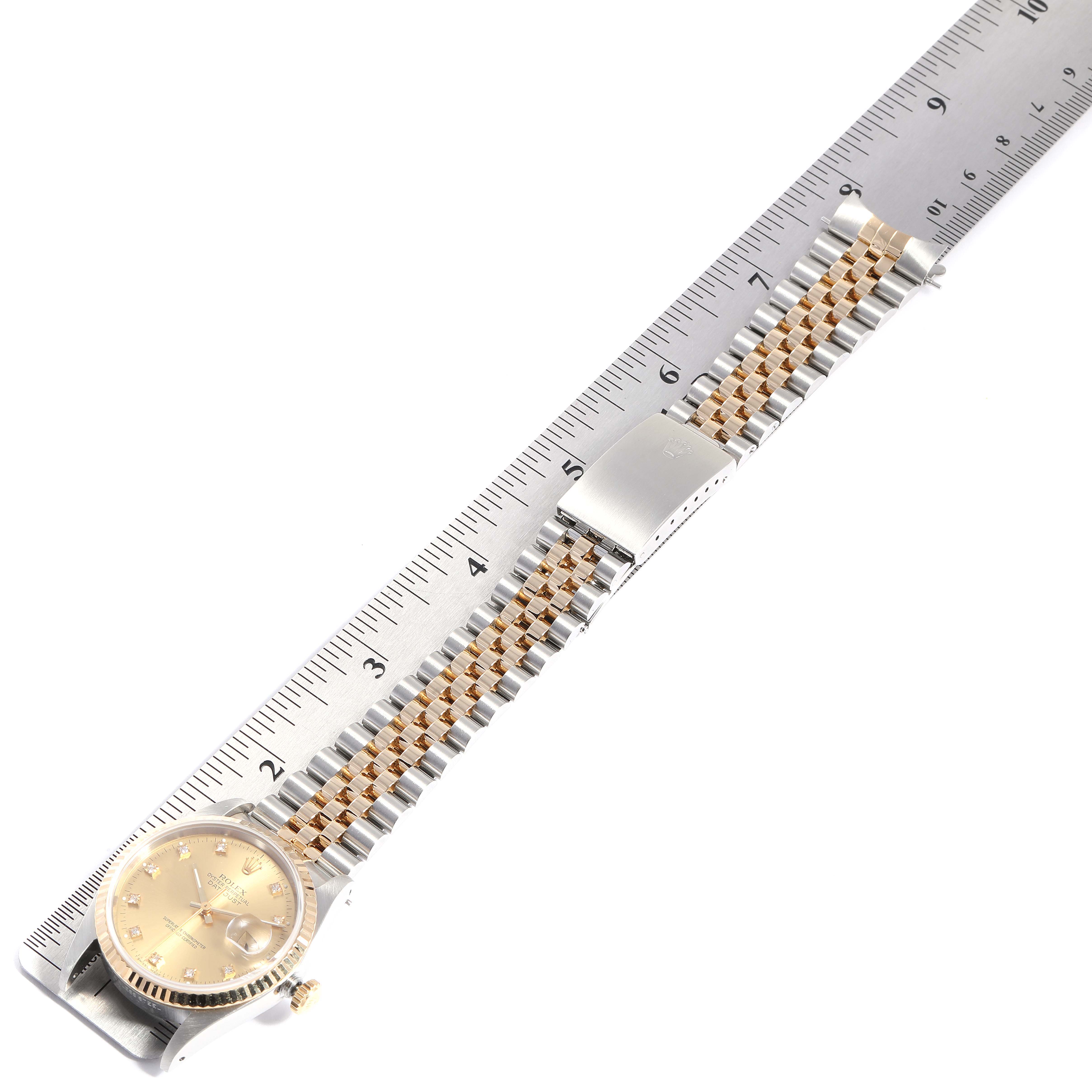 The image shows a top-down view of a Rolex Datejust 16233 Men
s Steel and Gold (two tone) Champagne Dial 16233 Men
s Steel and Gold (two tone) Champagne Dial watch, placed on a ruler to measure the length of its bracelet parts.