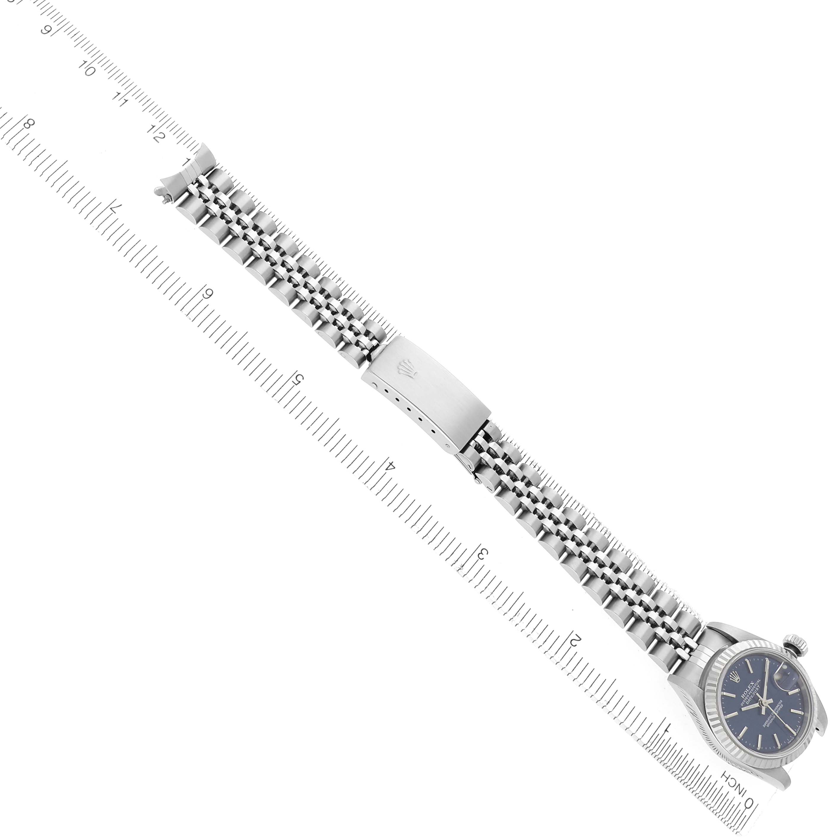 The Rolex Datejust 79174 Women
s Stainless Steel Blue Dial 79174 Women
s Stainless Steel Blue Dial watch is shown from a top-down angle, displaying the bracelet, clasp, and part of the watch face.