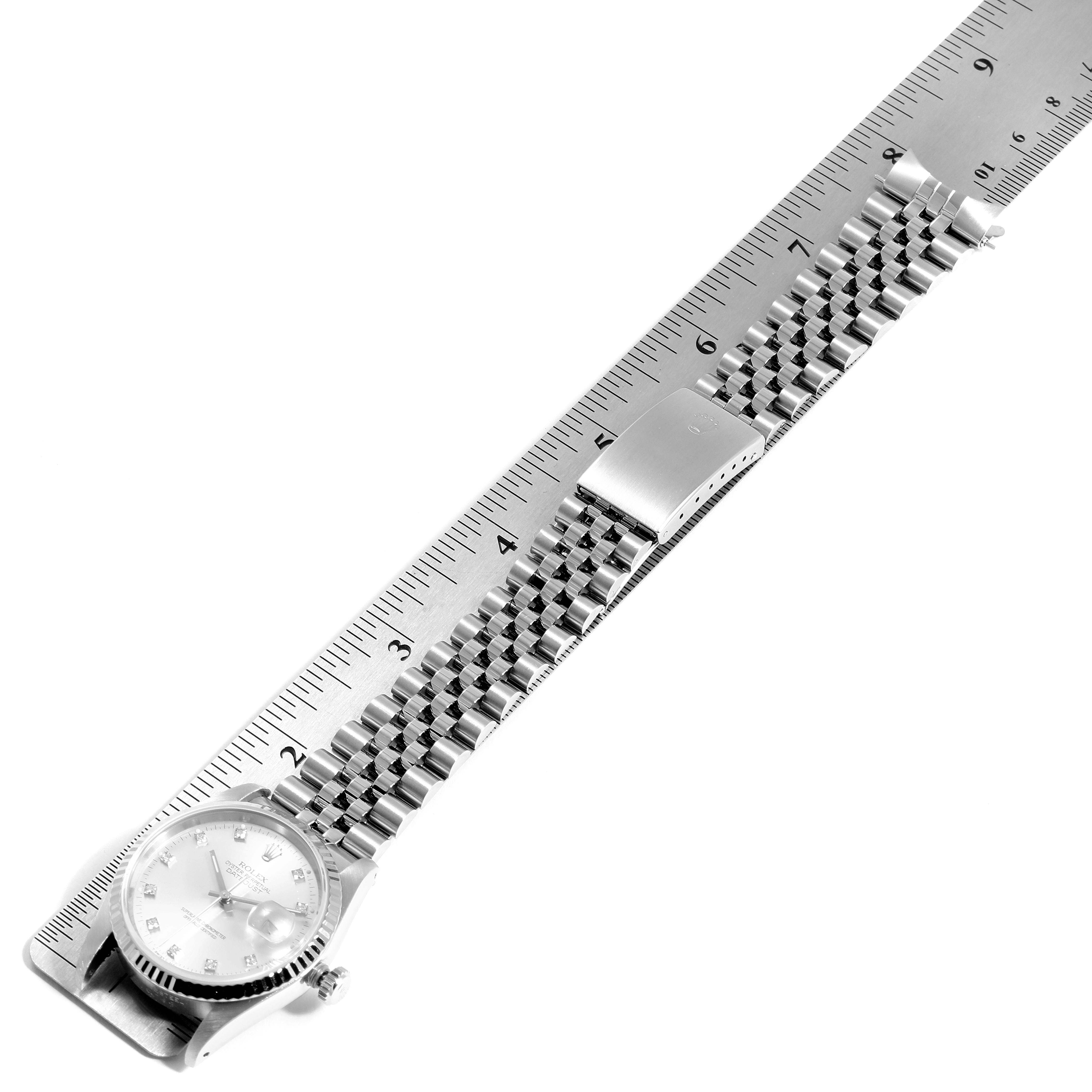 The image shows a Rolex Datejust 16234 Men's Stainless Steel Silver Dial 16234 Men's Stainless Steel Silver Dial model watch laid flat against a ruler, highlighting its bracelet and clasp.