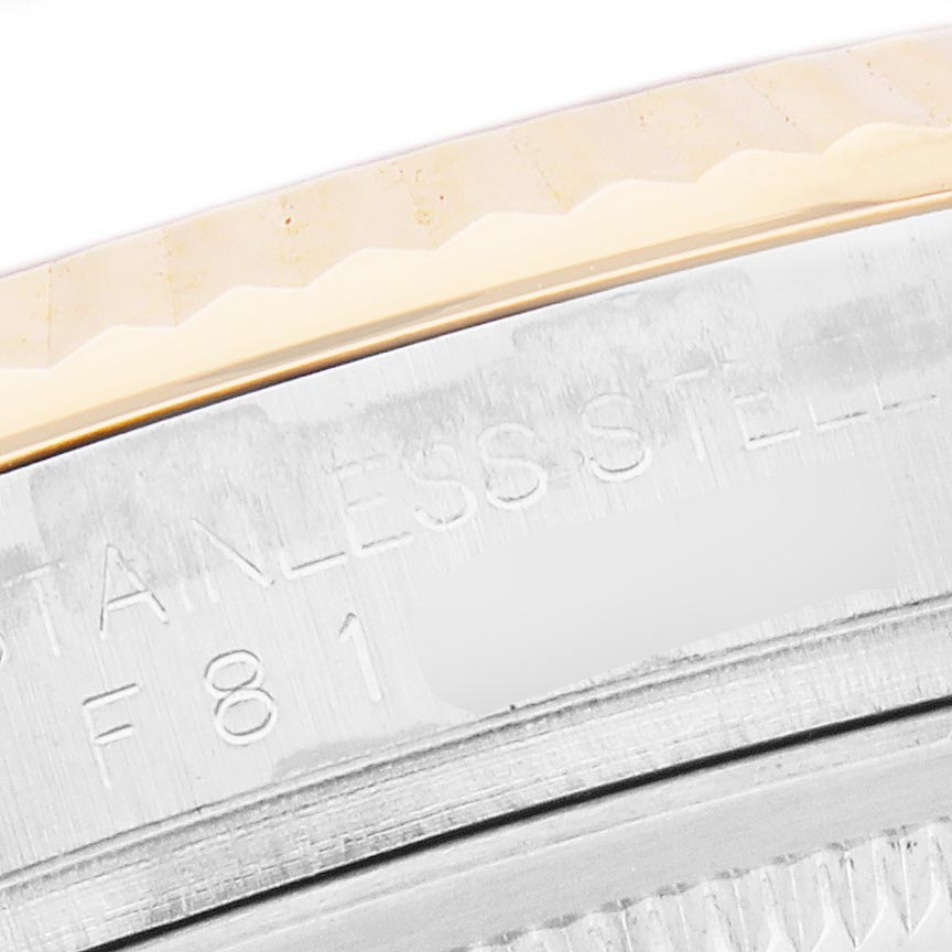 The image shows a close-up of the Rolex Datejust 116233 Men's Steel and Gold (two tone) Beige Dial 116233 Men's Steel and Gold (two tone) Beige Dial watch's fluted bezel and engraved stainless steel case.