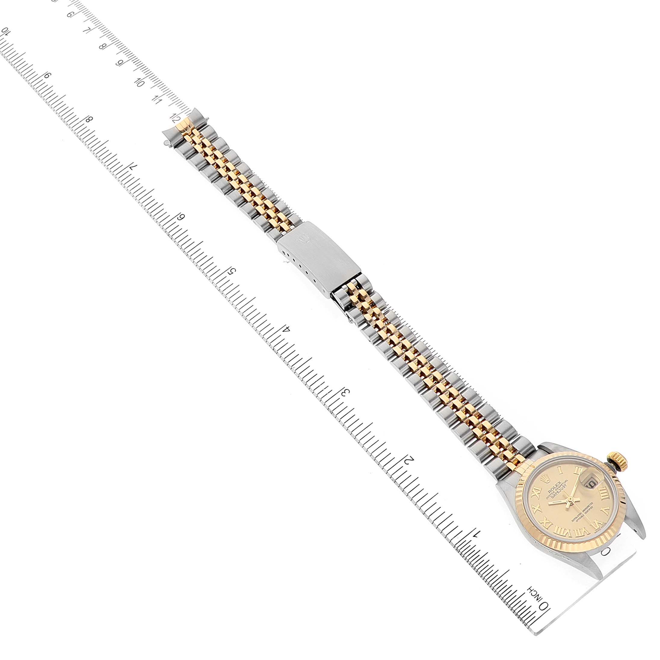 The image shows a Rolex Datejust 69173 Women
s Steel and Gold (two tone) Champagne Dial 69173 Women
s Steel and Gold (two tone) Champagne Dial watch laid flat alongside a ruler, displaying the full band and watch face.